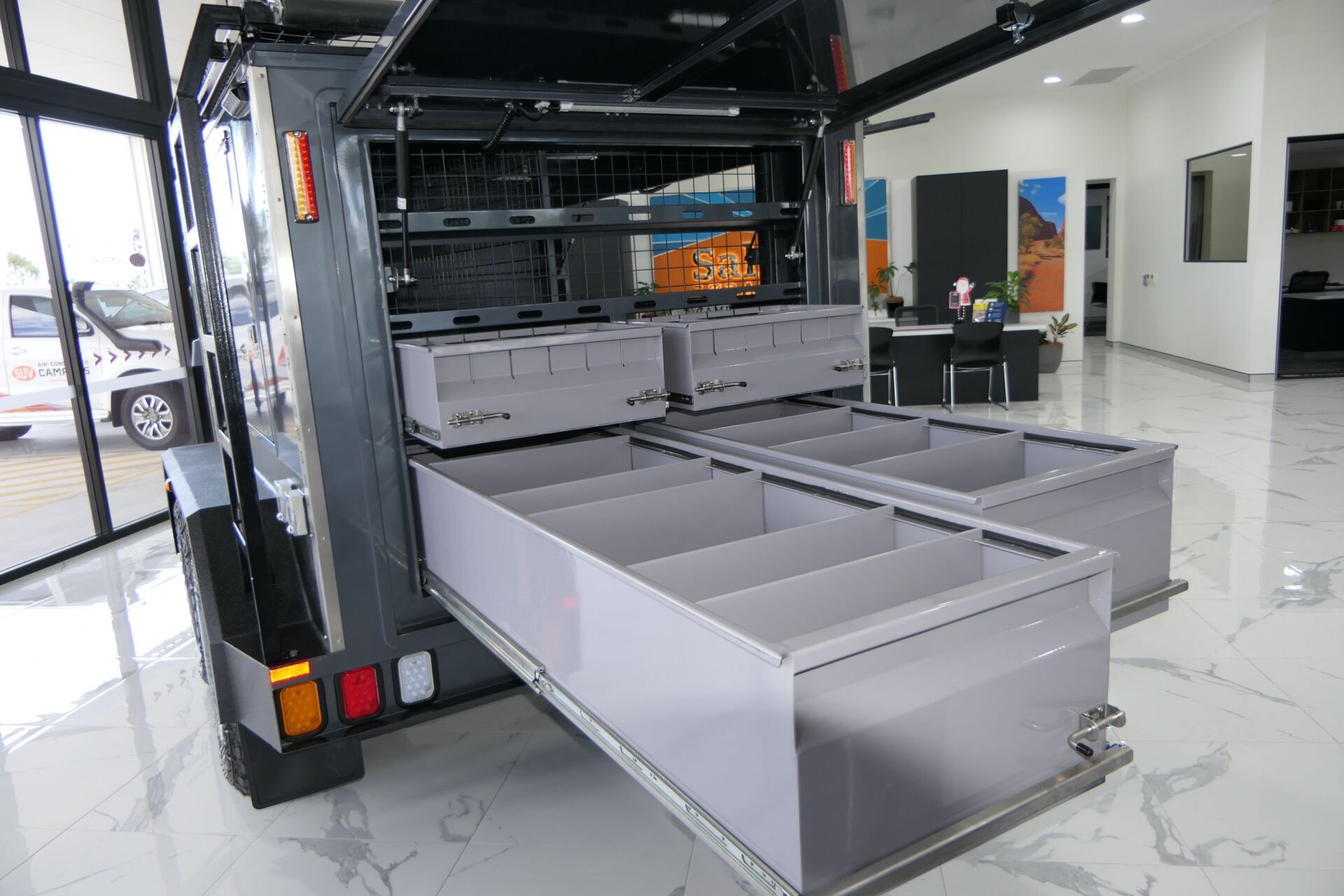 A trailer with drawers pulled out of it is sitting in a room.