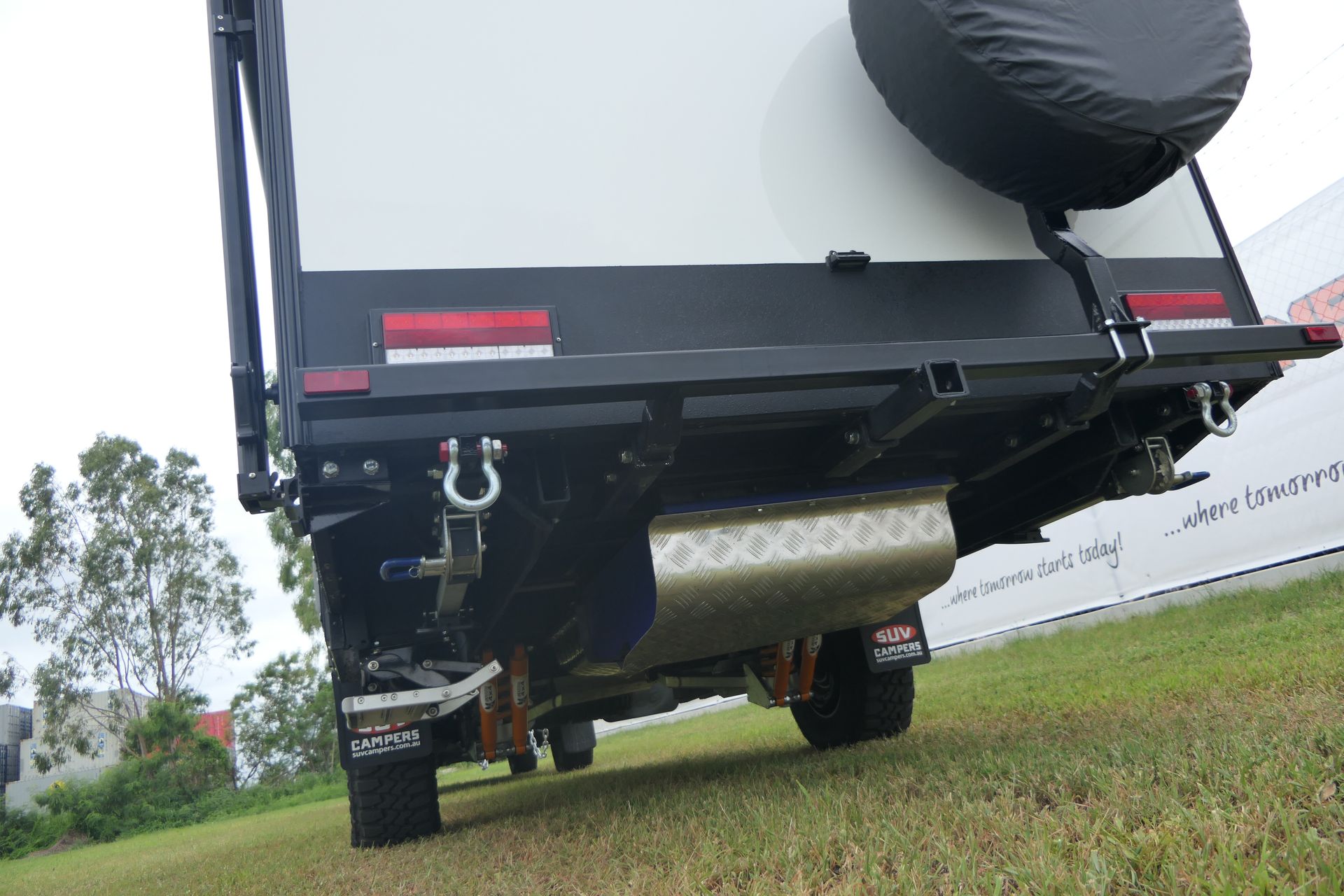 A white truck is parked in a grassy field.