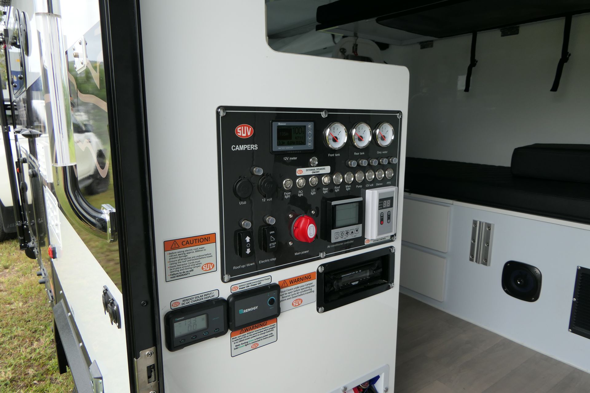 The inside of a camper with a lot of electronics on the wall.