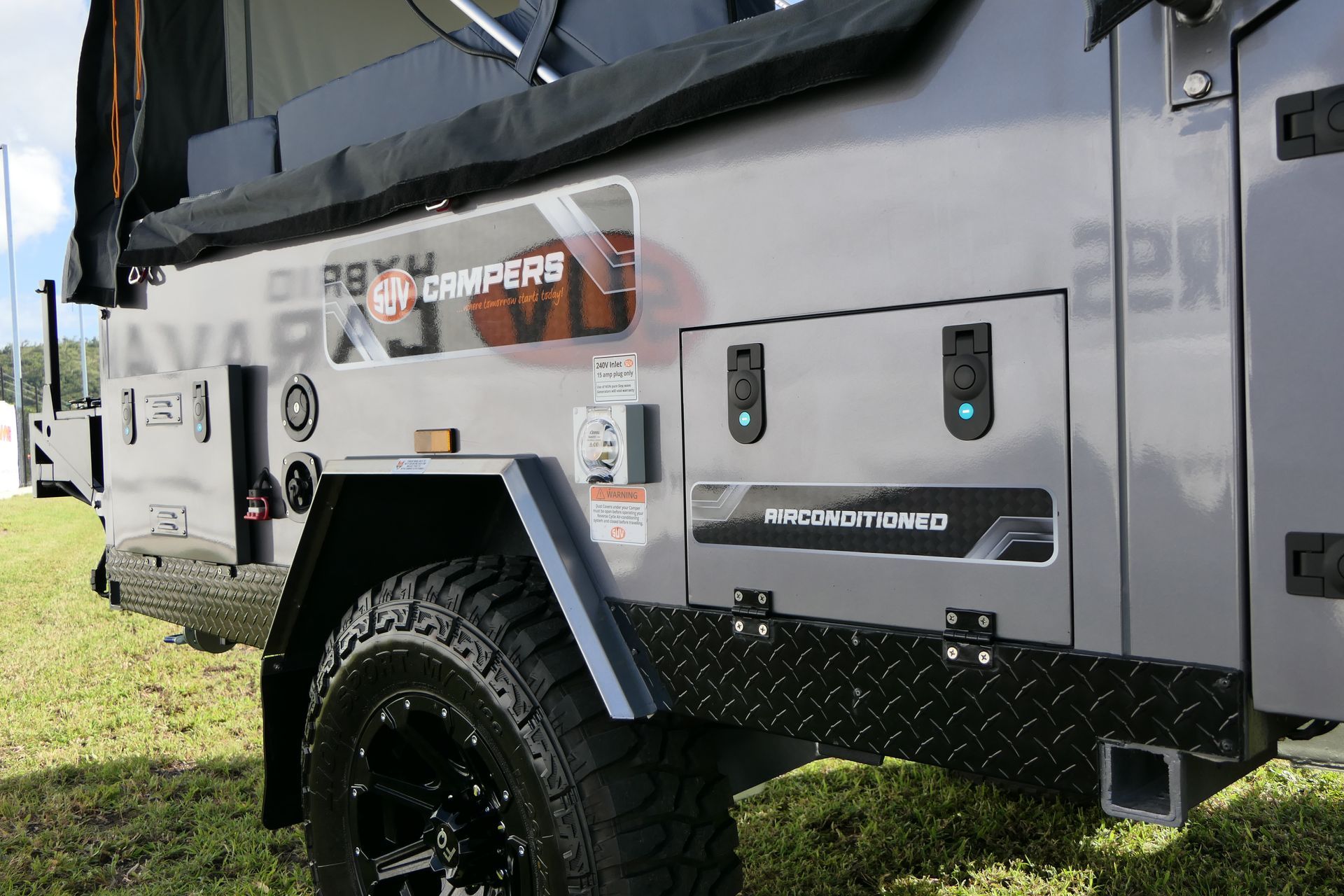 A camper trailer is parked in a grassy field.