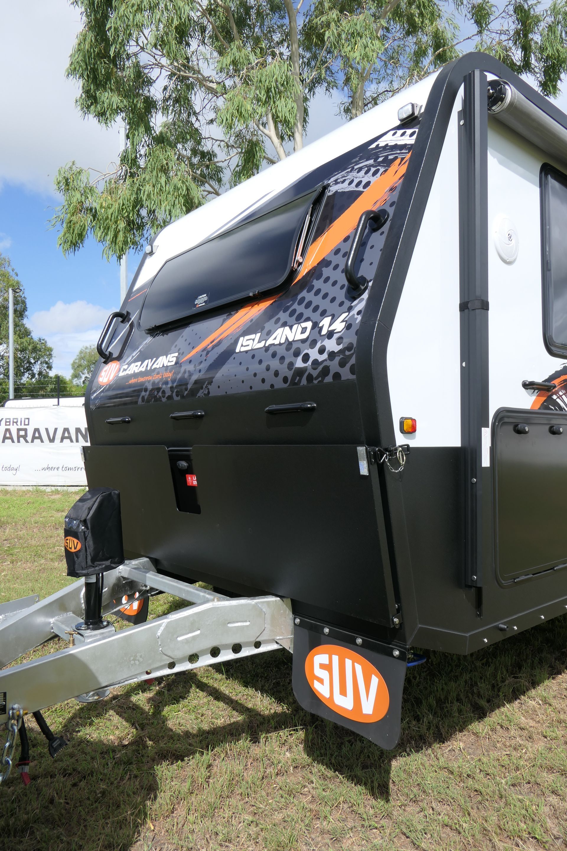 A black and white camper trailer is parked in a grassy field.