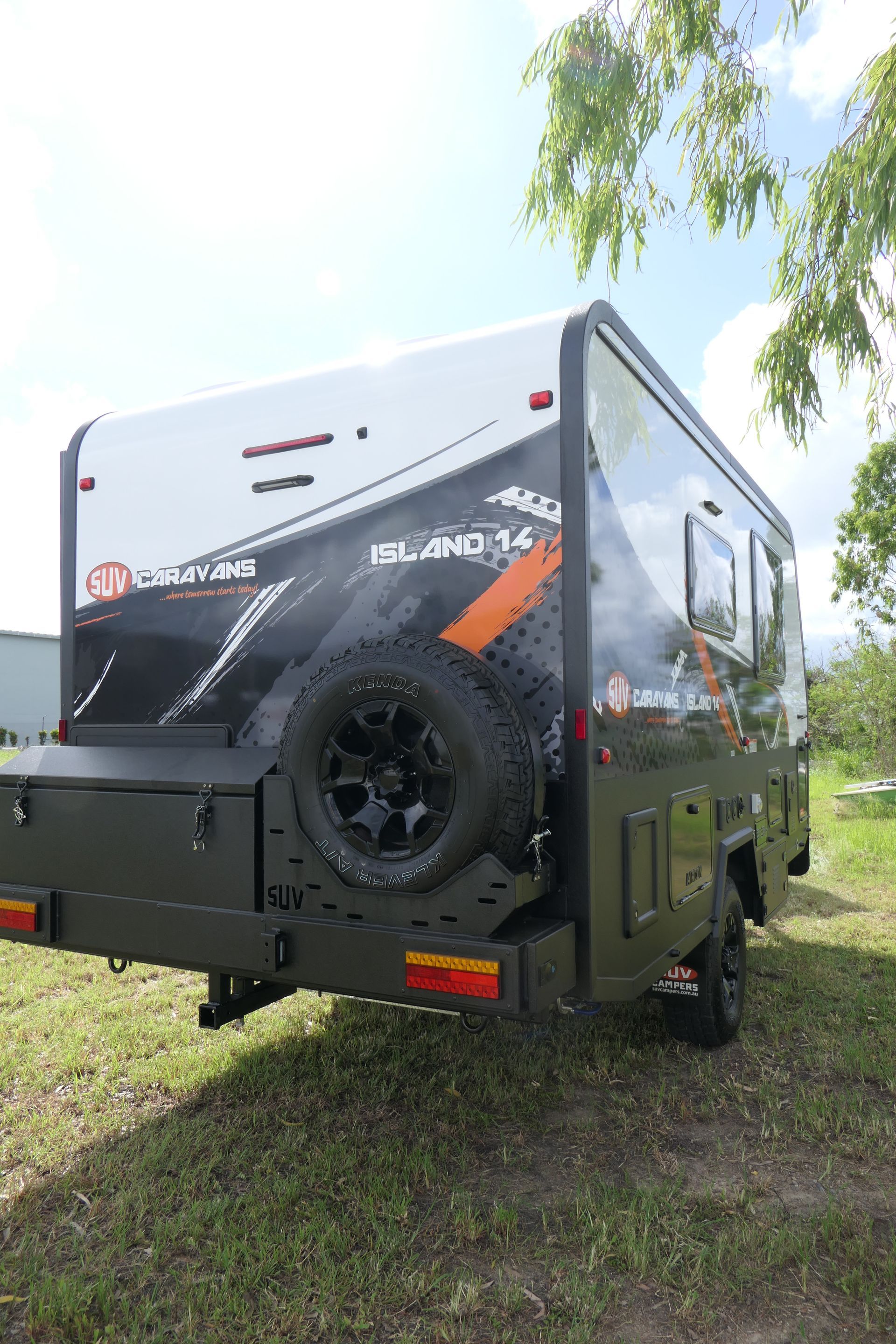 A camper trailer is parked in a grassy field.