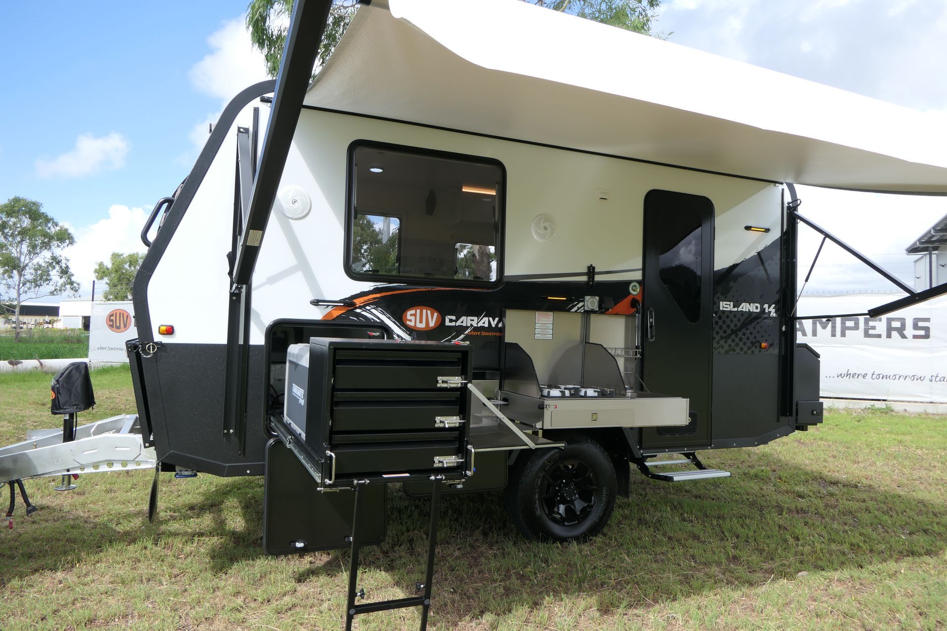 A camper trailer is parked in a grassy field.