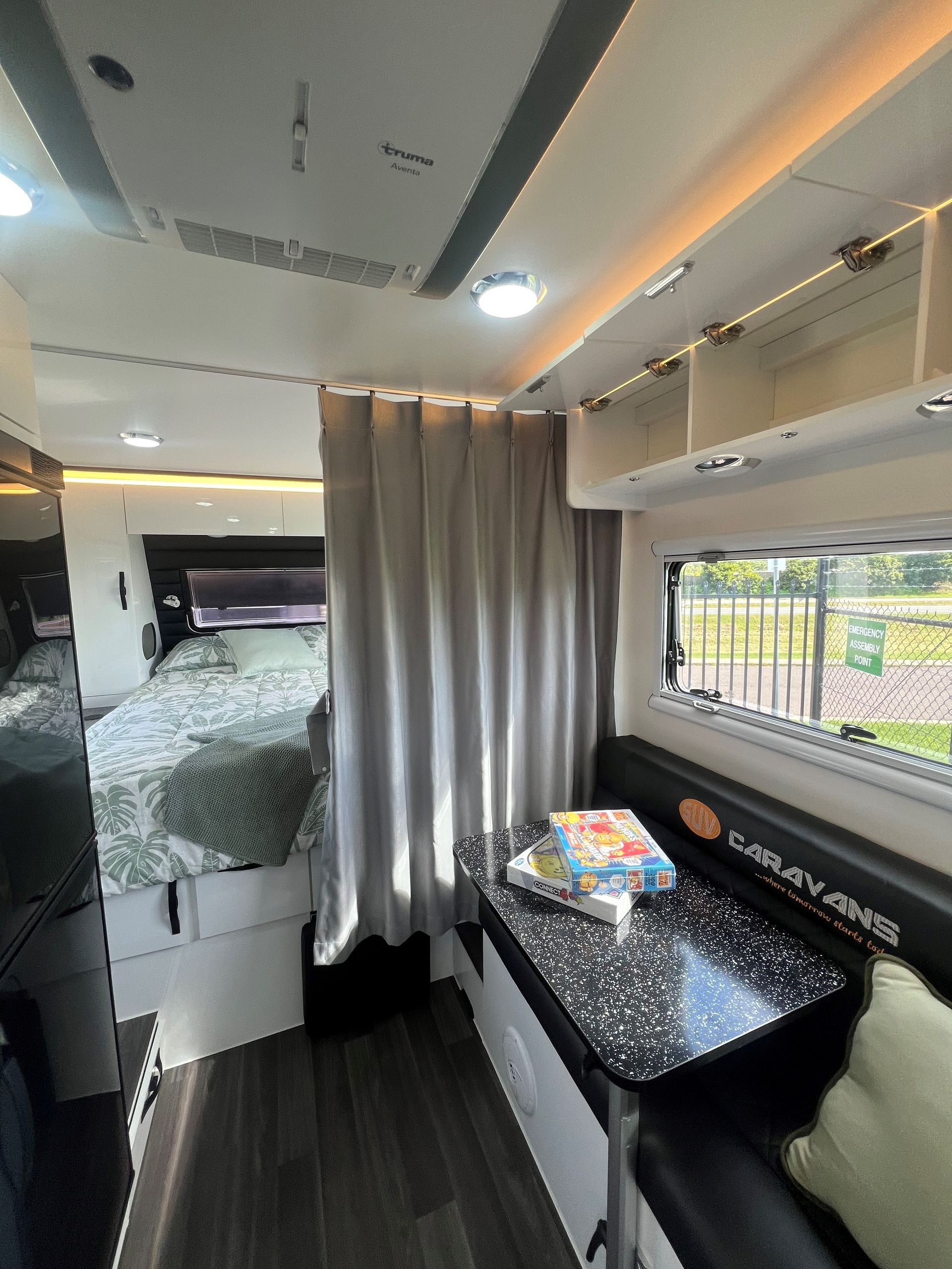 The inside of a camper van with a table and a bed.