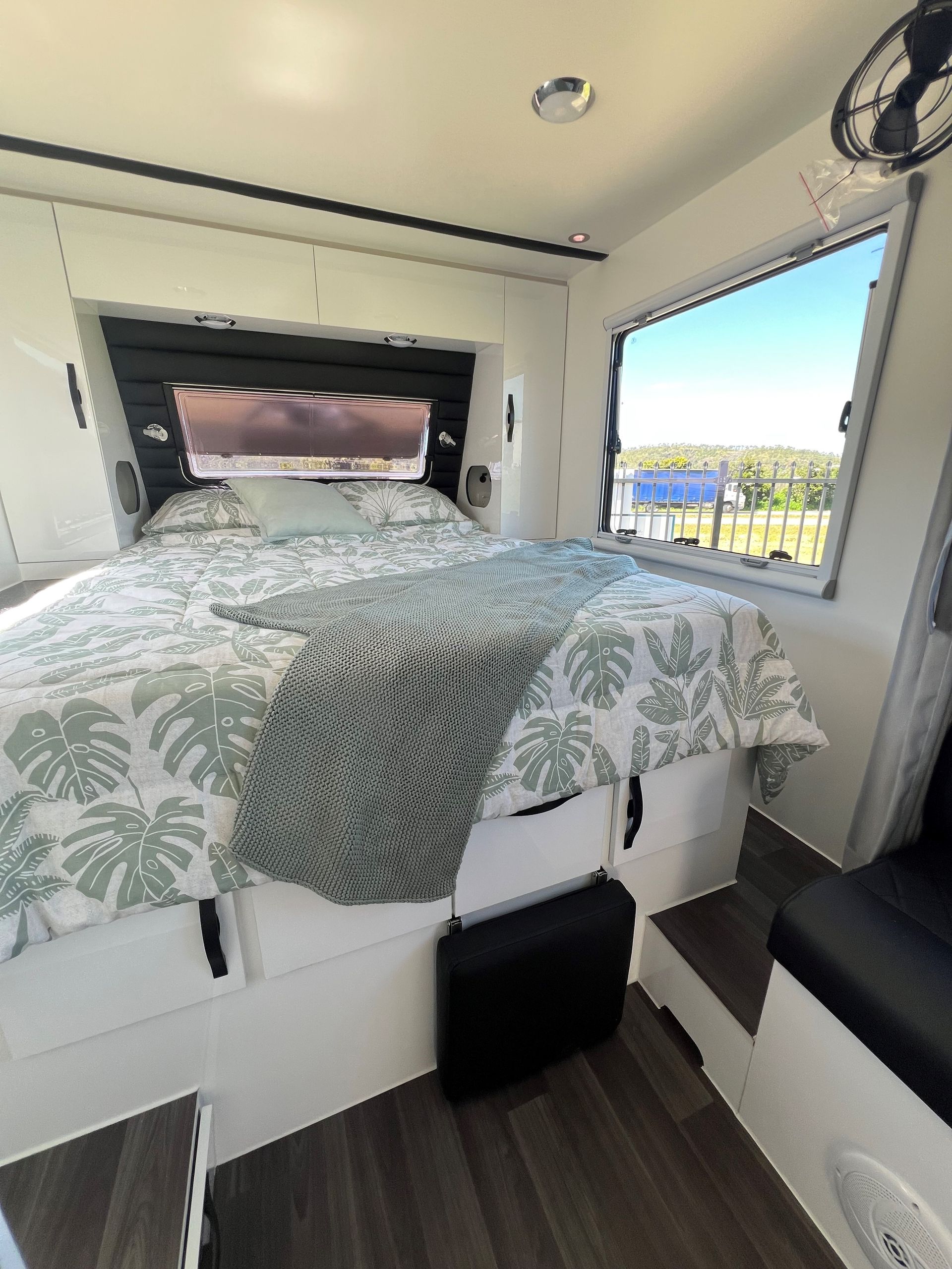A bedroom in a camper with a bed and a window.