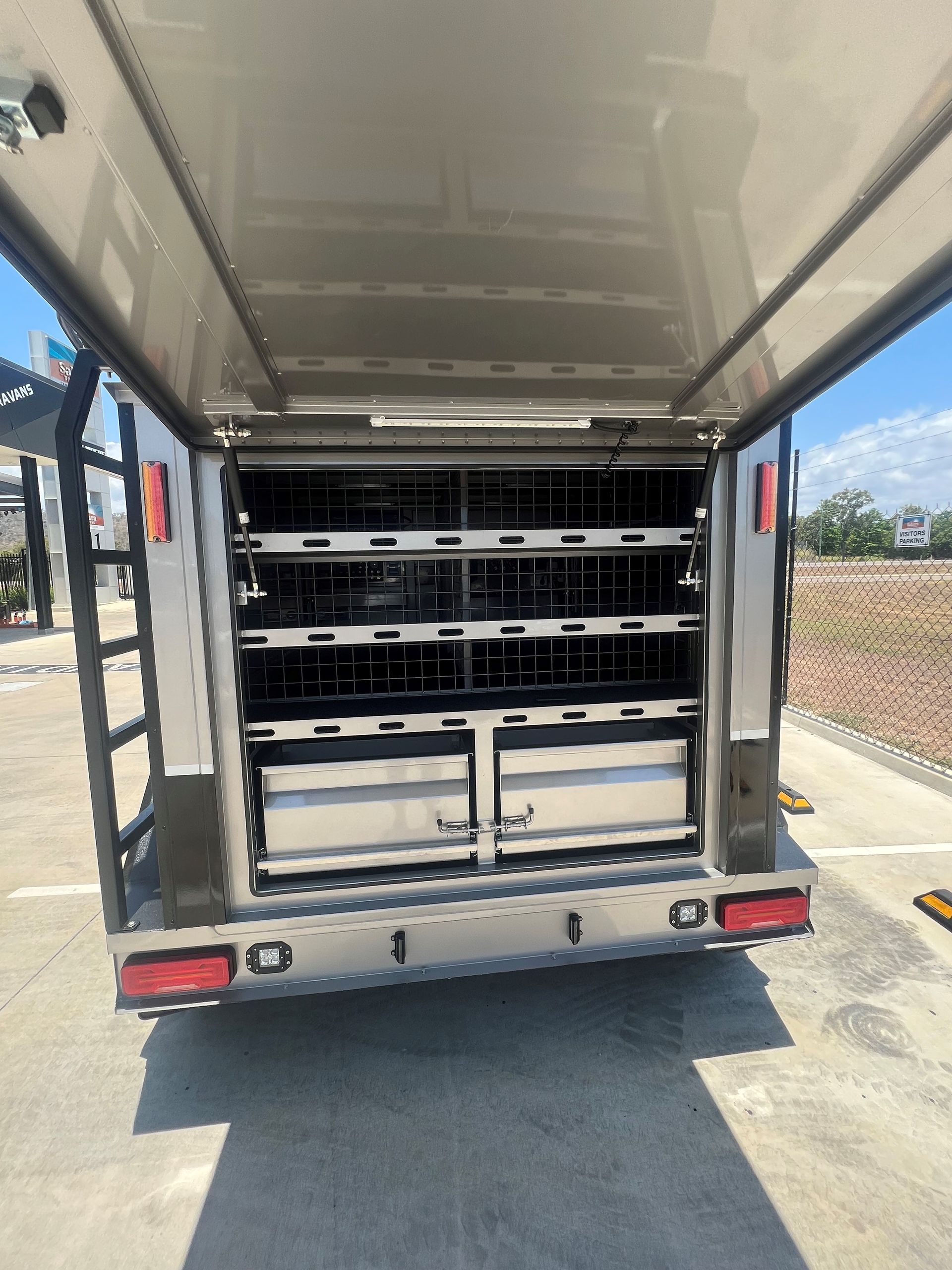 The back of a trailer with shelves and drawers.