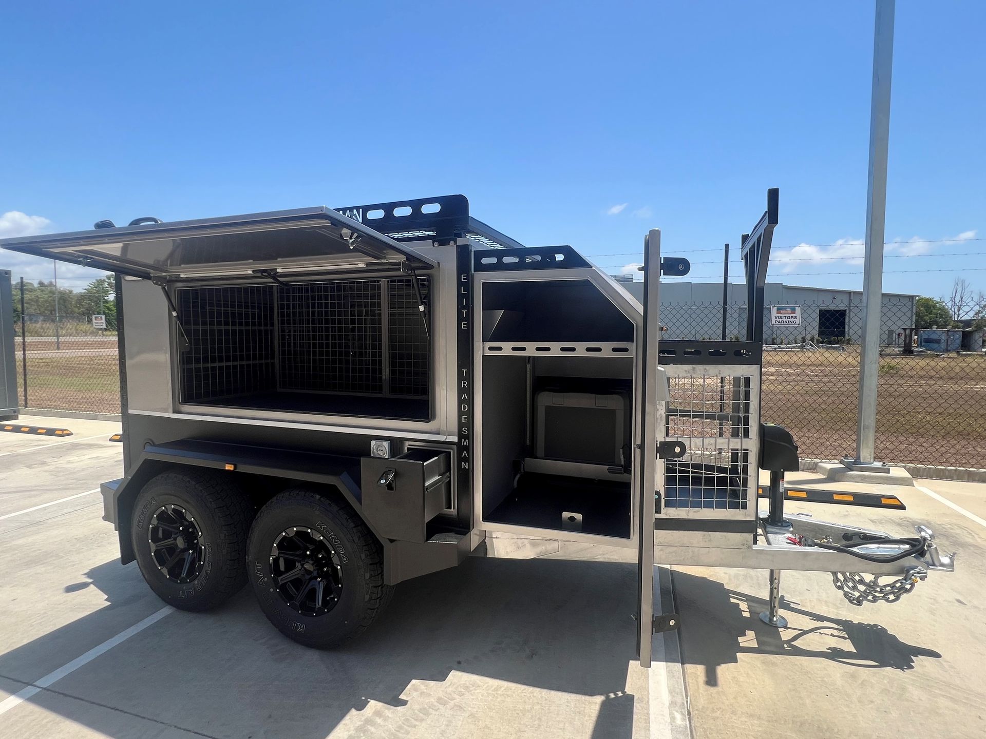 A trailer with the doors open is parked in a parking lot.