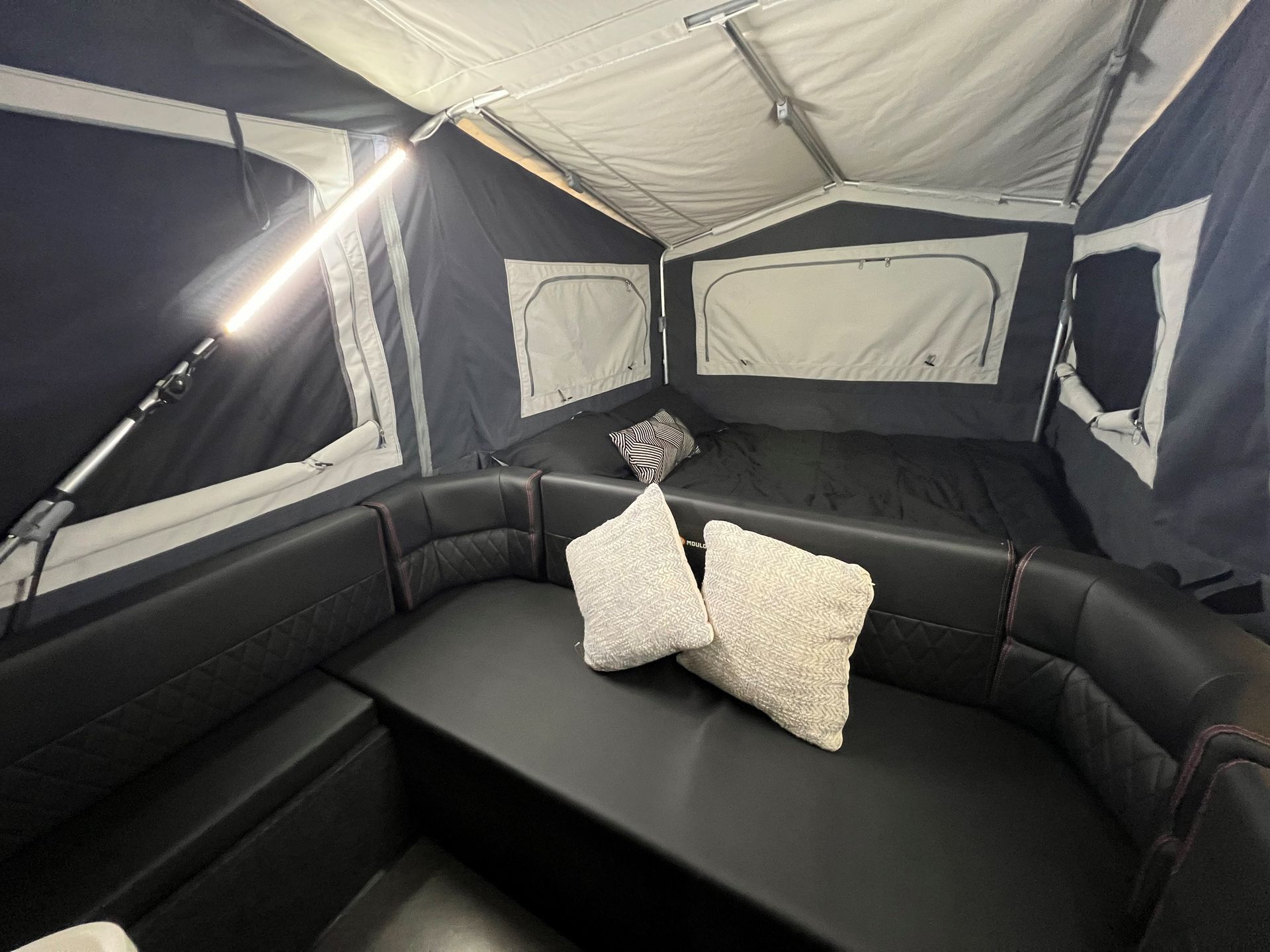 A tent with a couch and a bed inside of it.