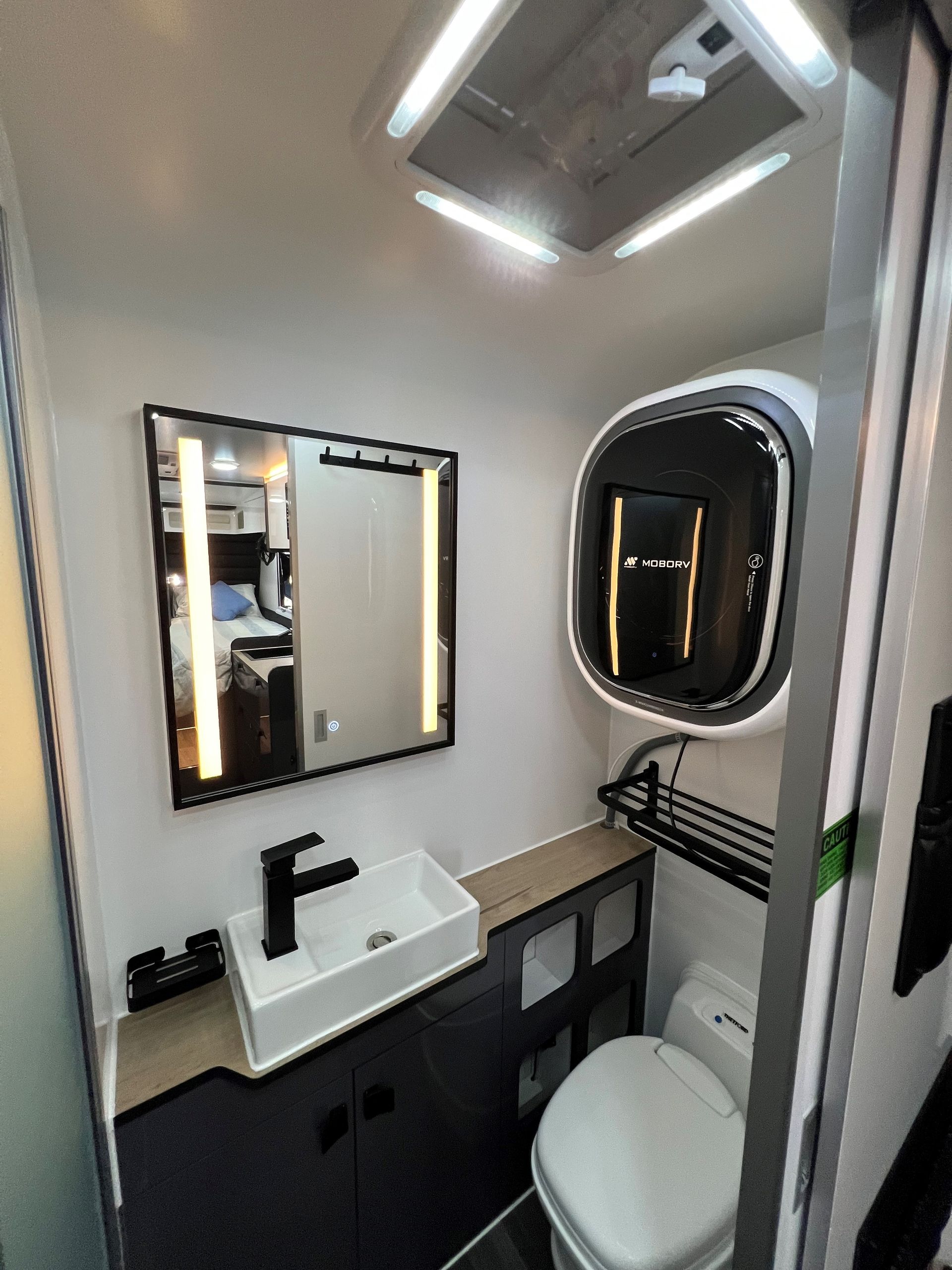 A bathroom with a toilet a sink and a mirror
