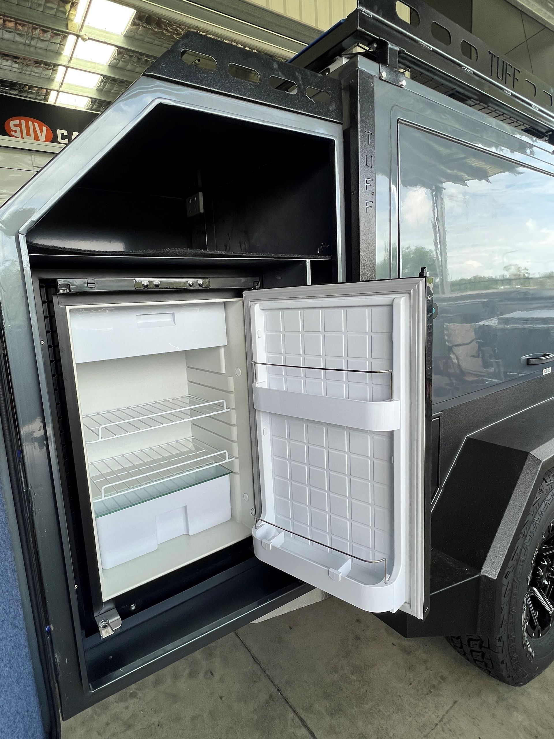 A car with the door open and a refrigerator inside of it.