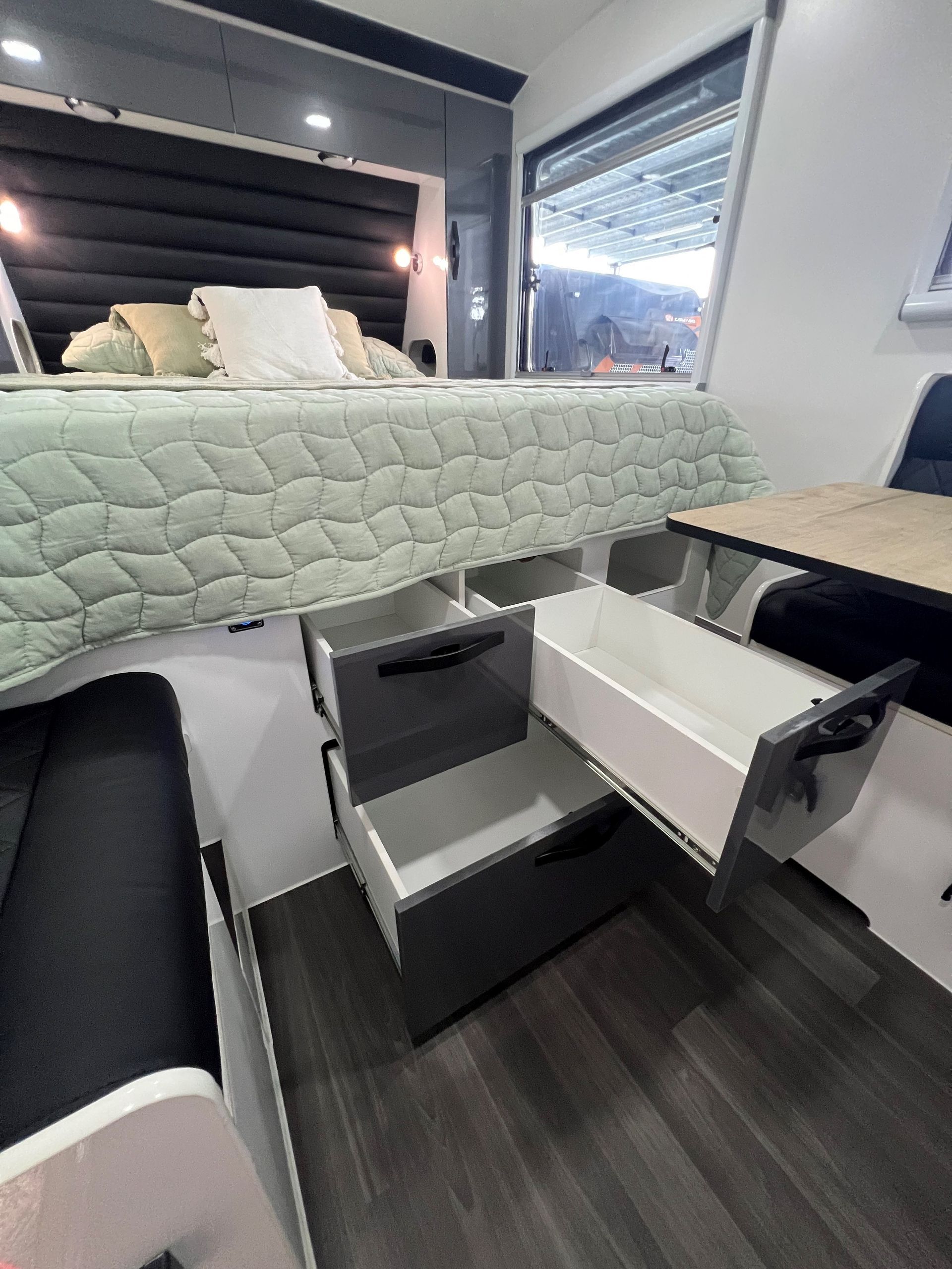 A bedroom with a bed and drawers underneath it.