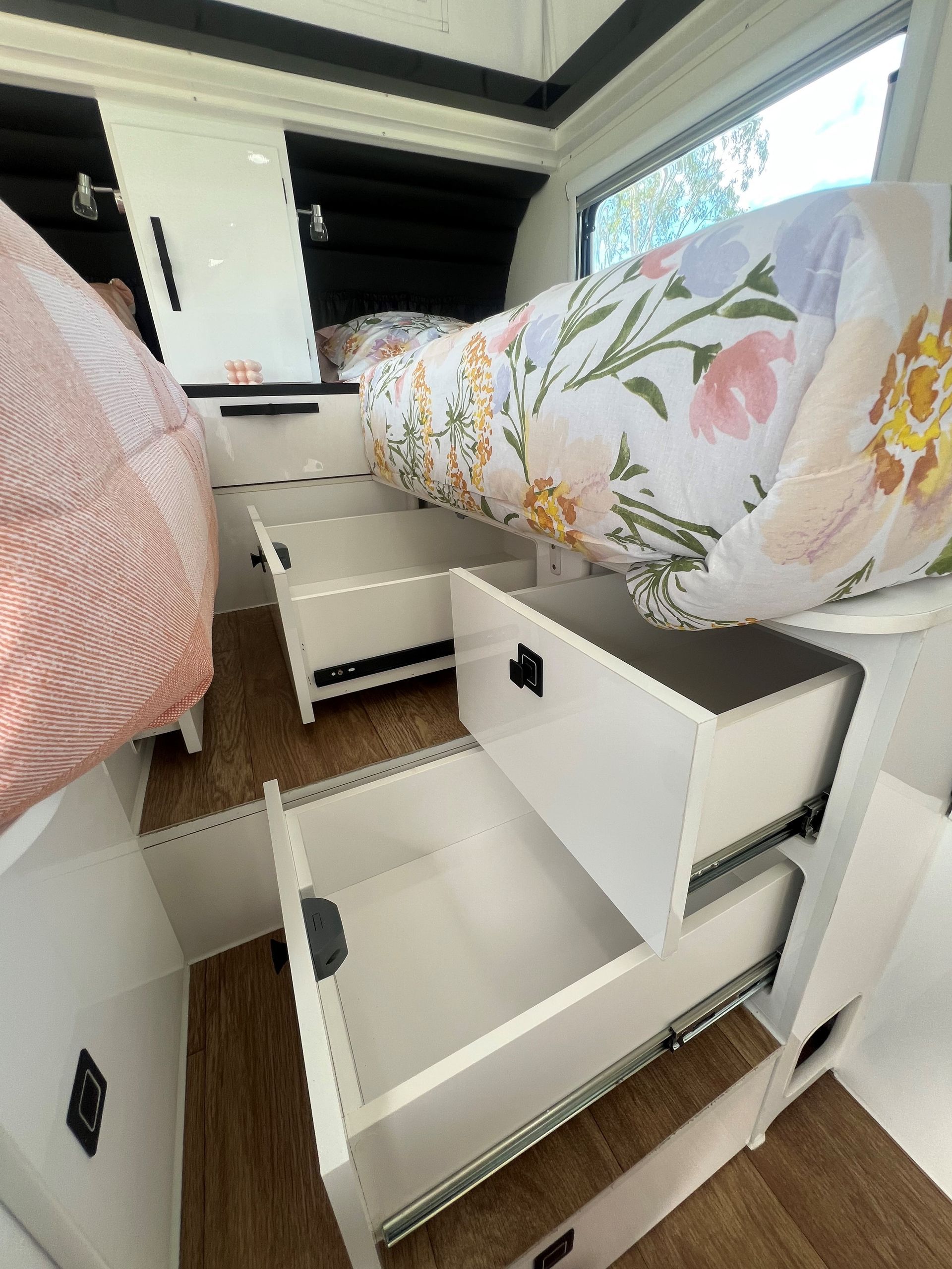 A bed with drawers underneath it in a camper.