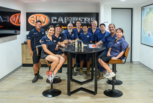 A group of people standing around a table in a room.