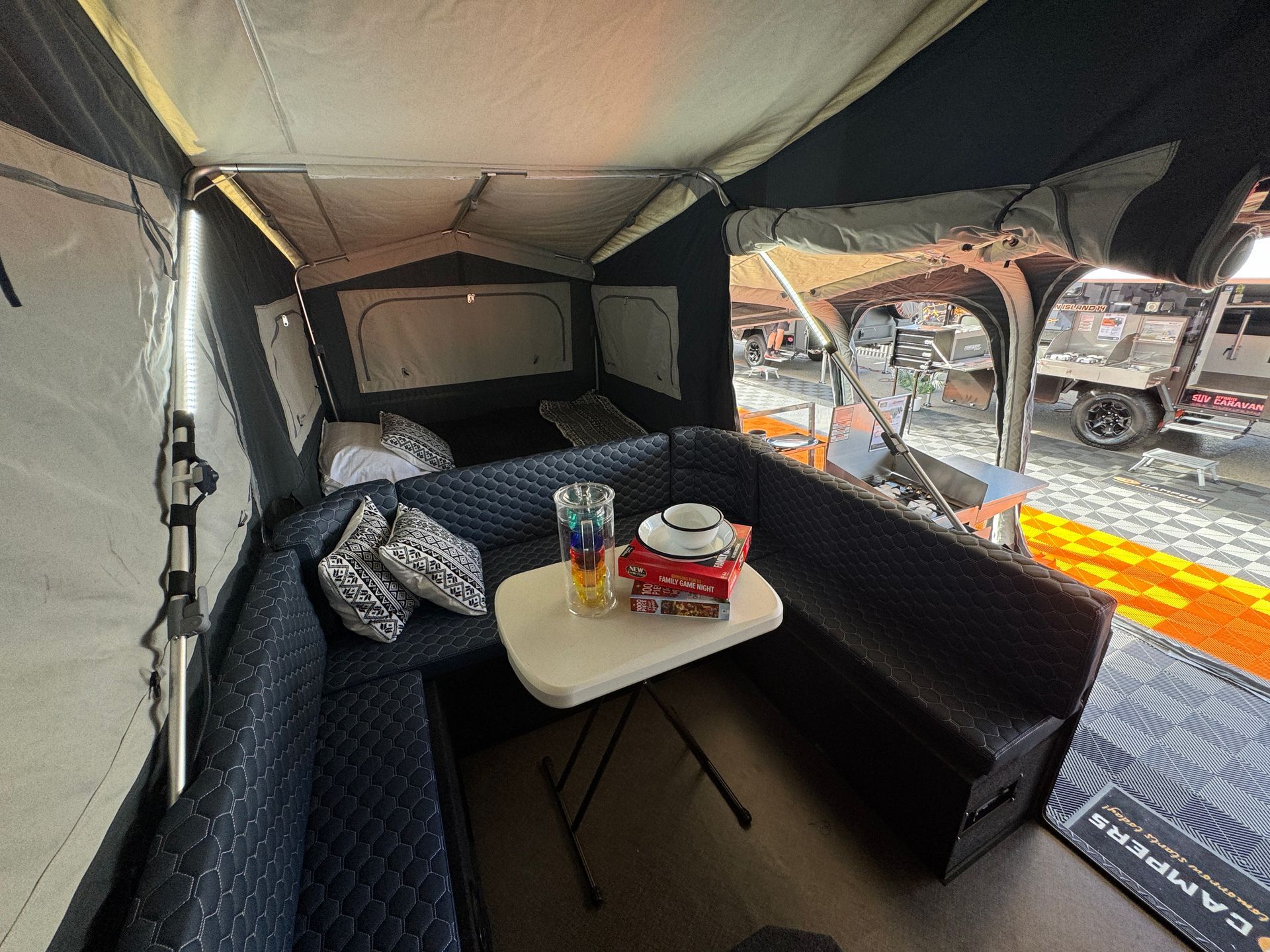 The inside of a tent with a table and a couch.