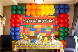 A room decorated for a tea party with balloons and a table.