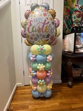 A bunch of balloons are stacked on top of each other on a wooden floor.