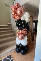 A bunch of balloons are sitting on top of a wooden table.