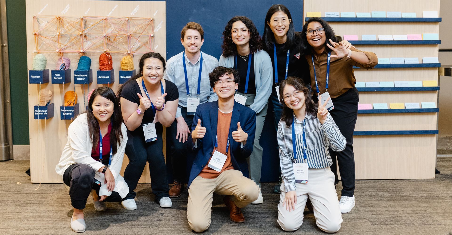 A group of people are posing for a picture in front of a wall.