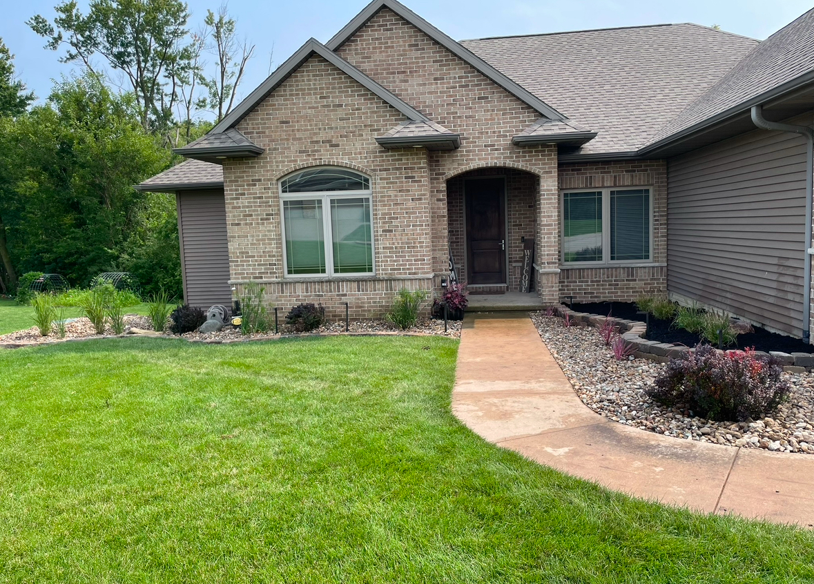 A large brick house with a walkway leading to the front door.