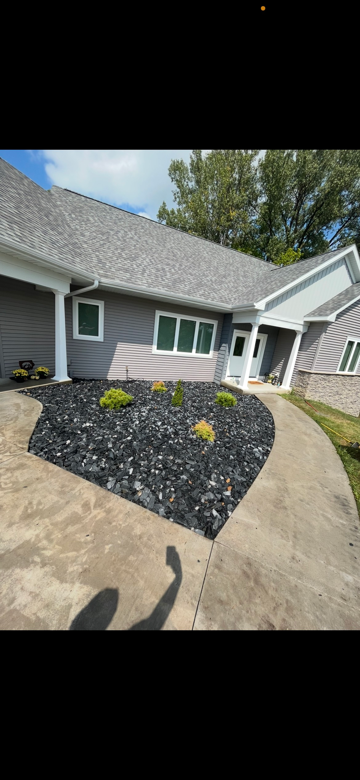 A brick house with a lush green lawn and a sidewalk in front of it.