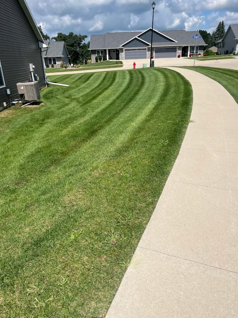 A large brick house with a walkway leading to the front door.