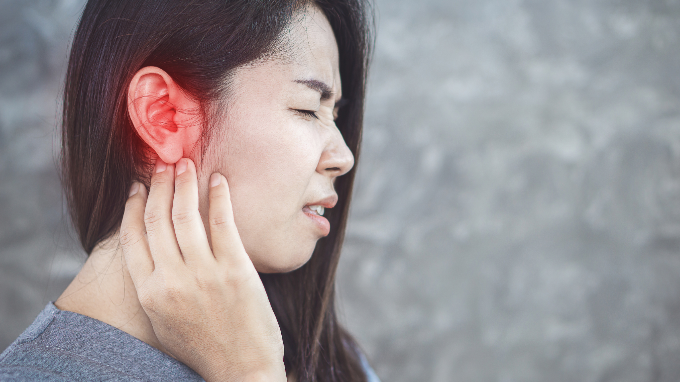A Woman rubbing her ear wondering it is it an Ear Infection vs. Hearing Loss. She wants to Know the Signs so she is visiting Frequency Hearing's blog