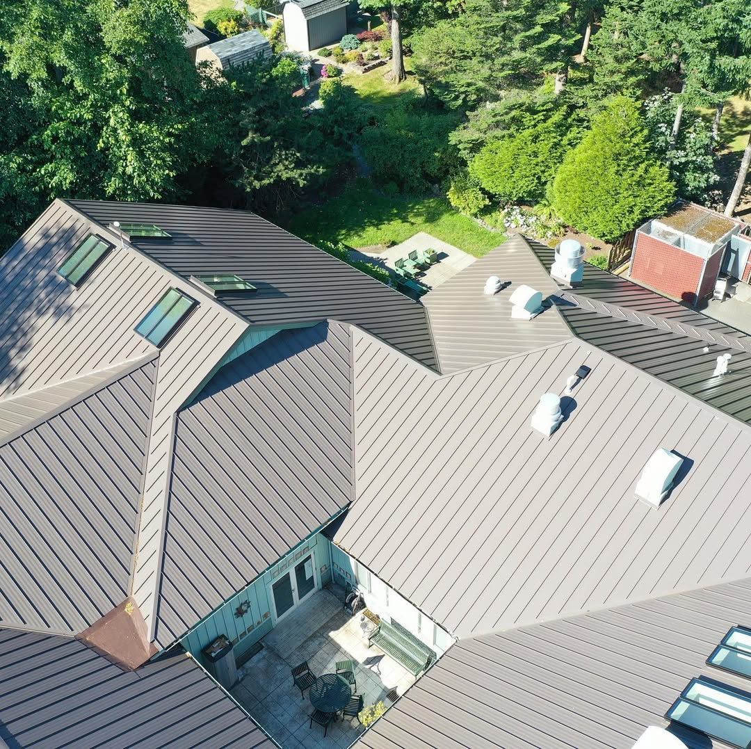 An aerial view of a house with a roof that has a lot of windows.