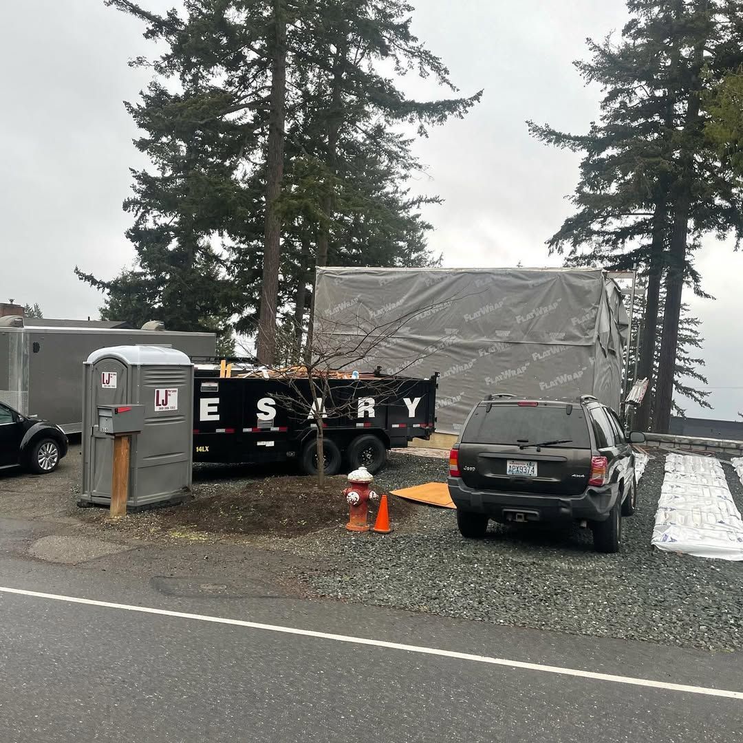 A car is parked on the side of the road next to a dumpster.