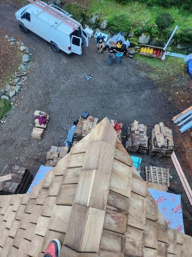 A person is standing on top of a wooden roof.