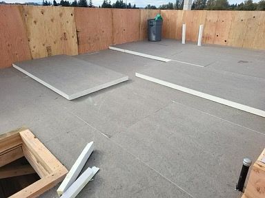 A room with a concrete floor and a wooden wall.