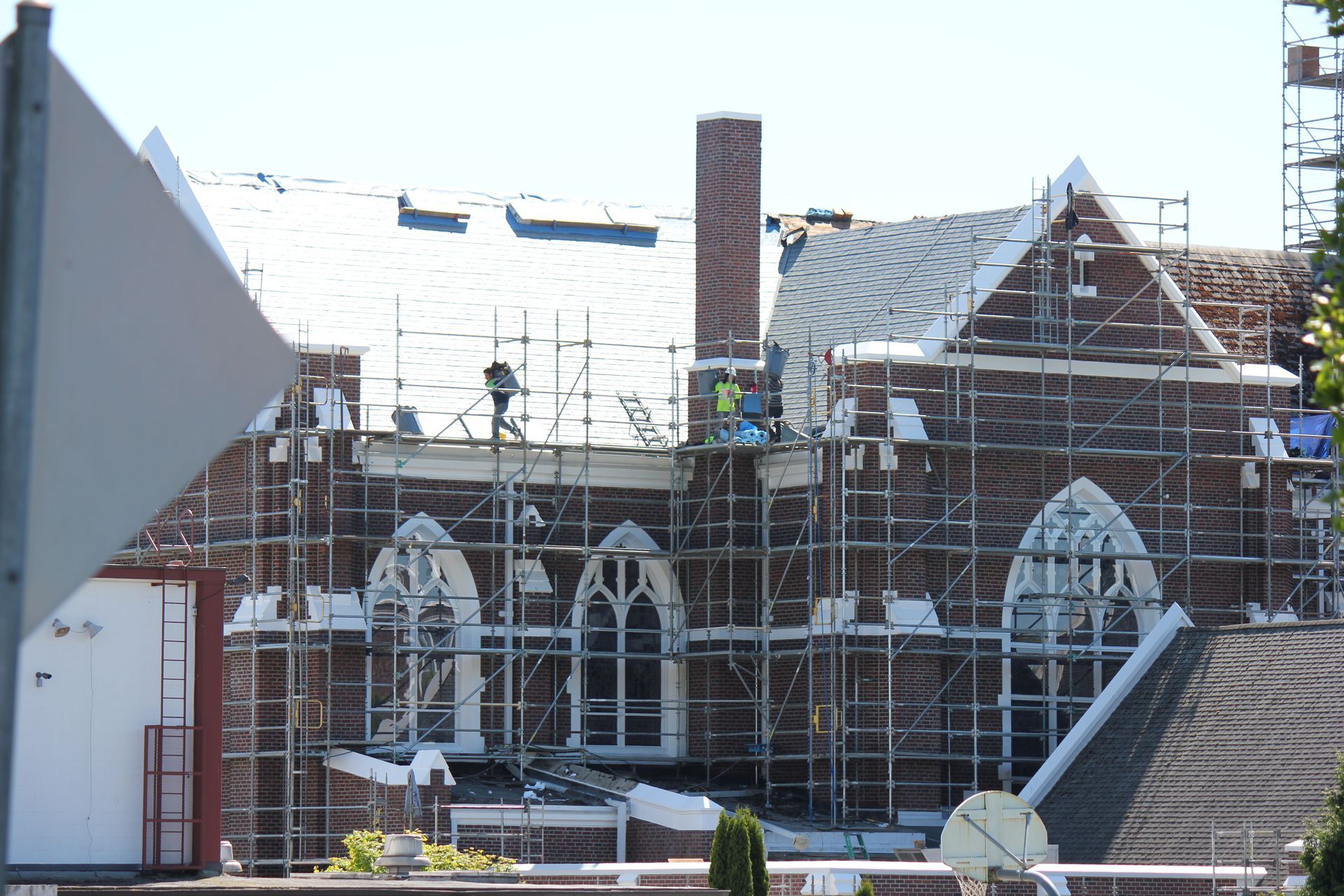 A brick building with scaffolding around it is being remodeled.