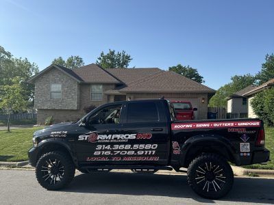 Black service pickup truck parked in front of a suburban house on a sunny day