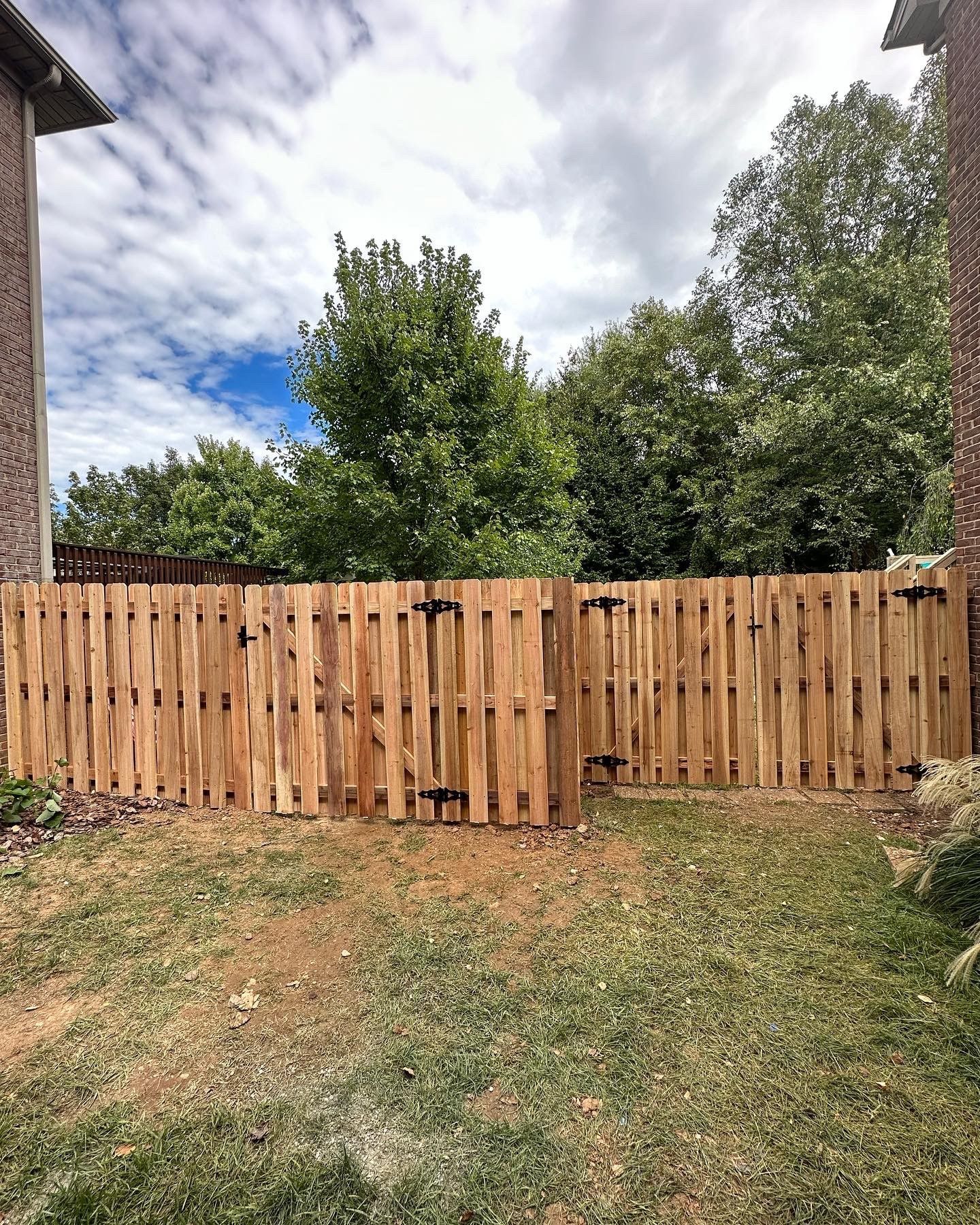 a wooden fence is in the backyard of a house — Lexington, KY — Chafin Fence LLC