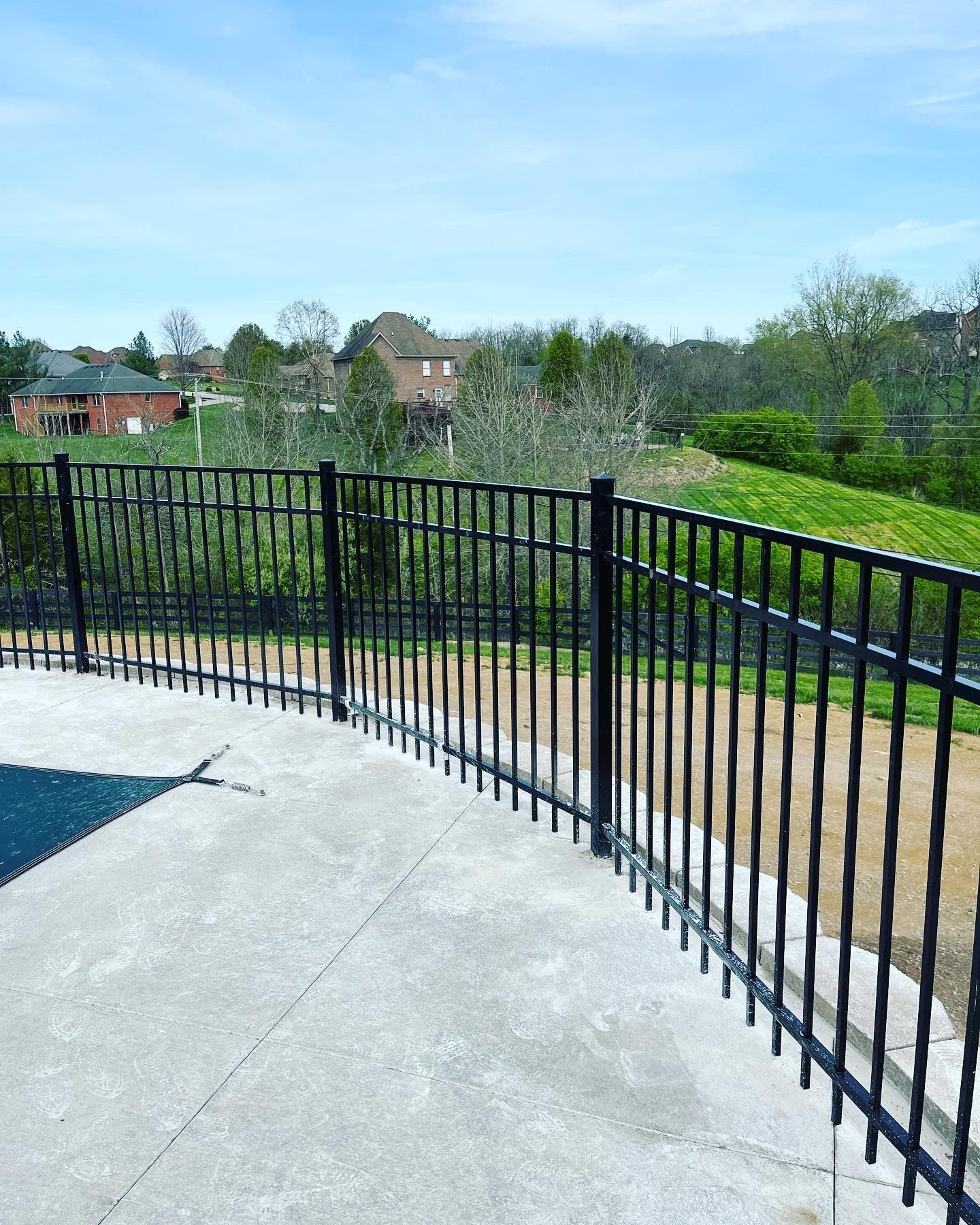 a black metal fence surrounds a swimming pool — Lexington, KY — Chafin Fence LLC