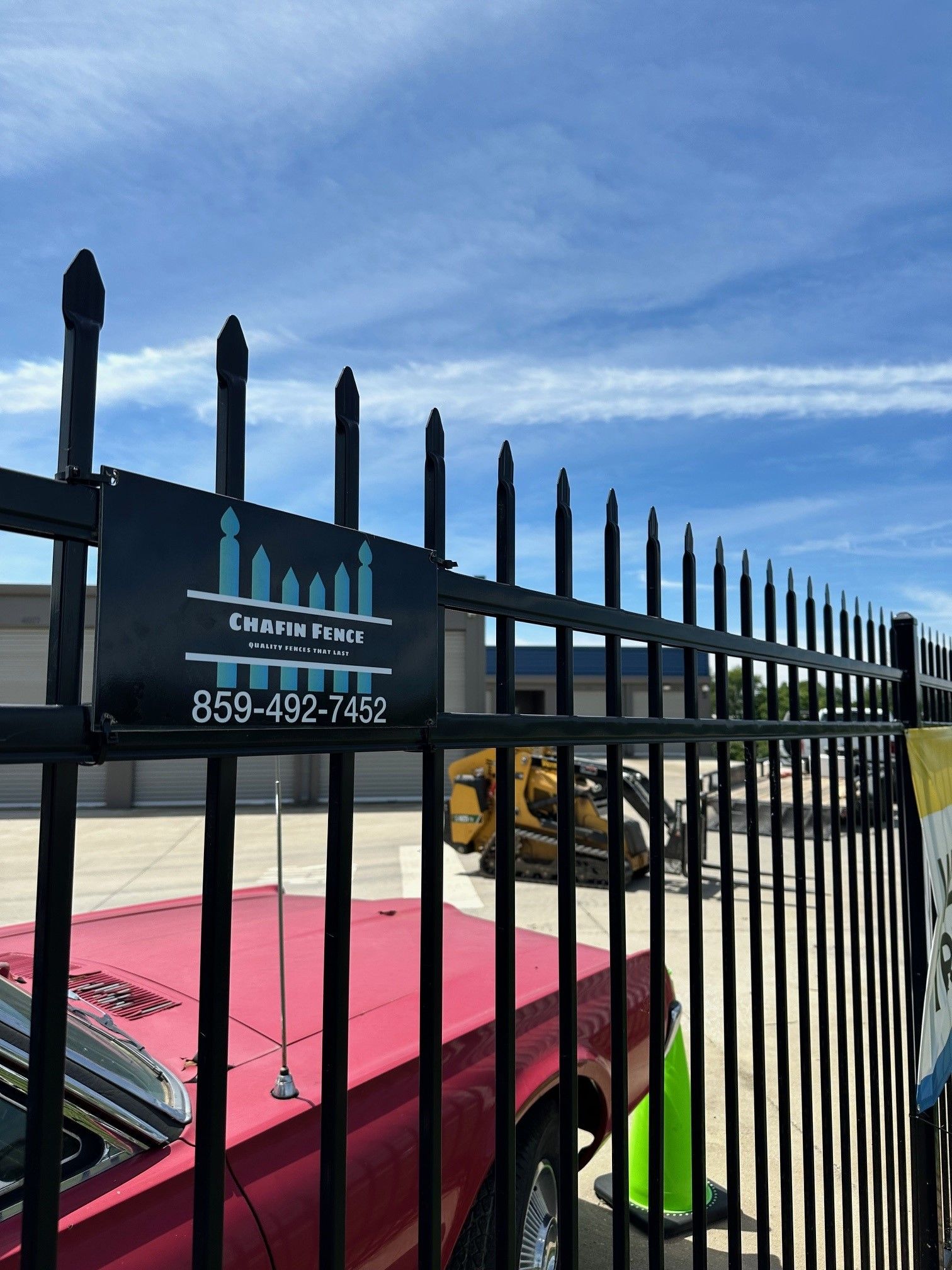 A red truck is parked behind a fence with a sign that says chris point