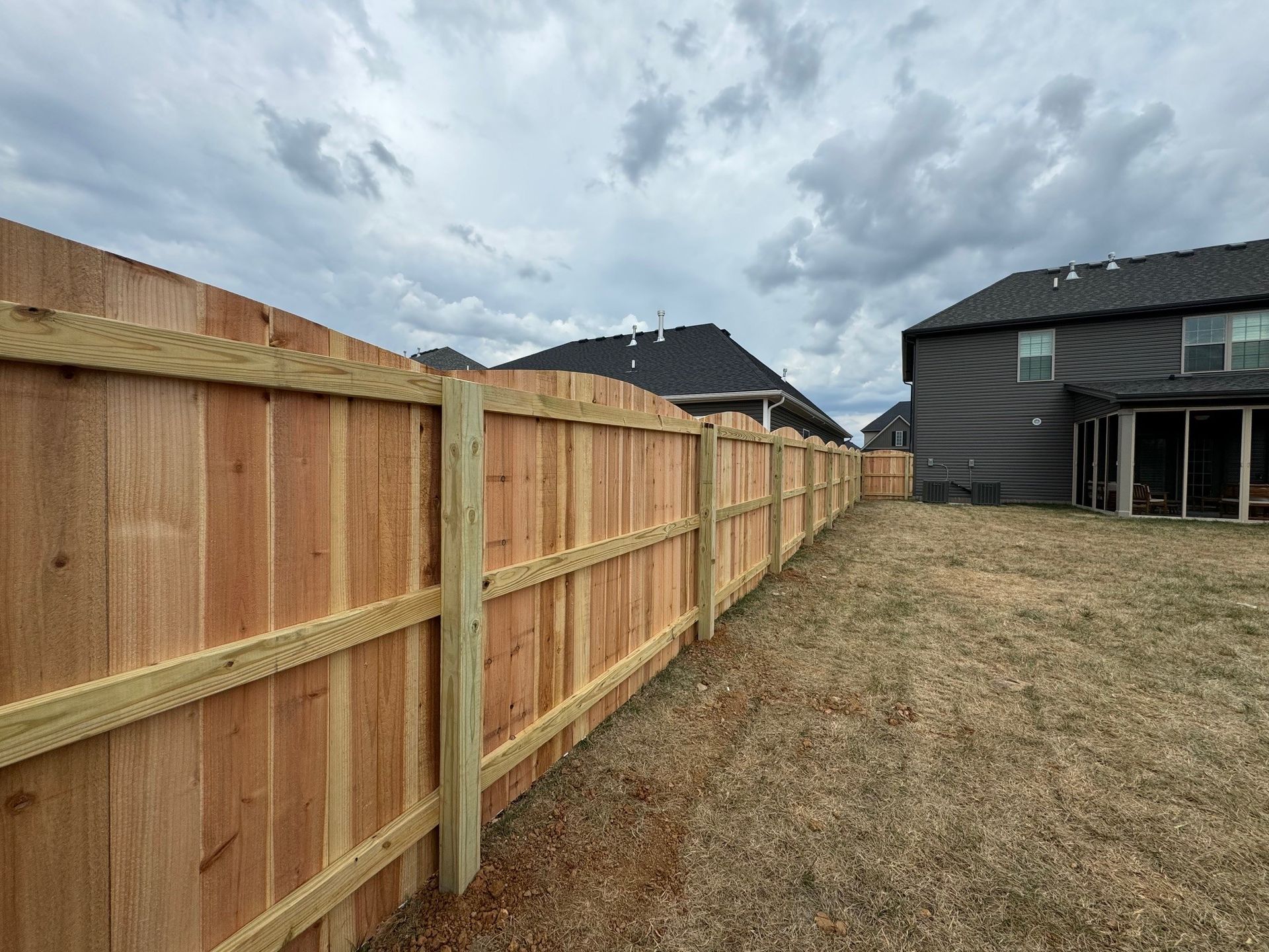 A wooden fence is in the backyard of a house — Lexington, KY — Chafin Fence LLC