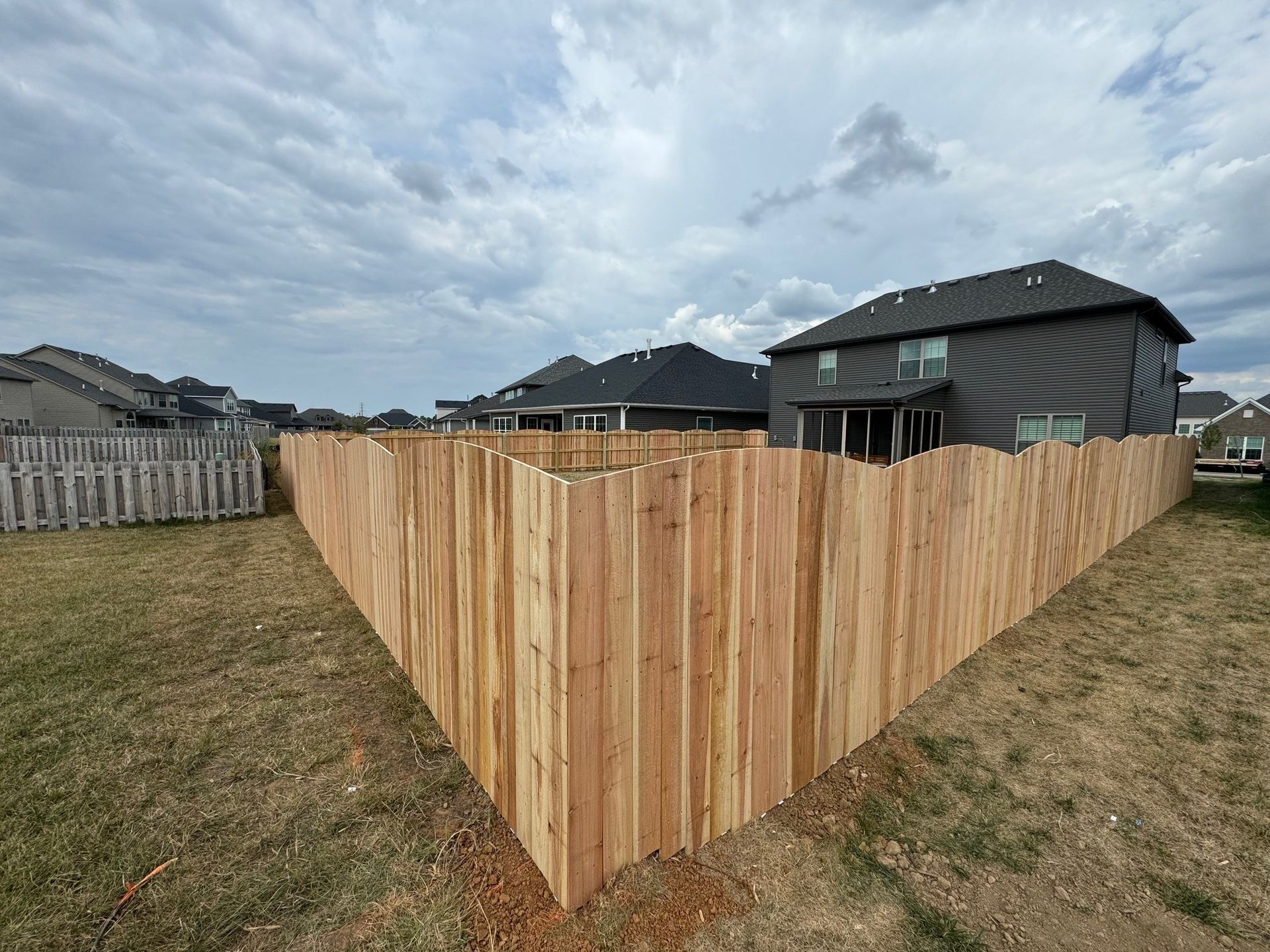 A wooden fence is in the backyard of a house — Lexington, KY — Chafin Fence LLC