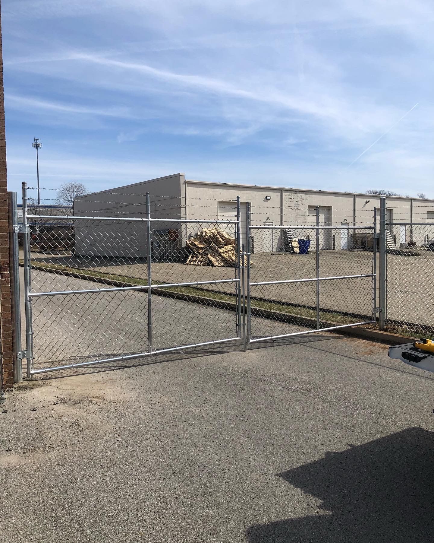 a chain link fence is surrounding a parking lot with a building in the background — Lexington, KY — Chafin Fence LLC