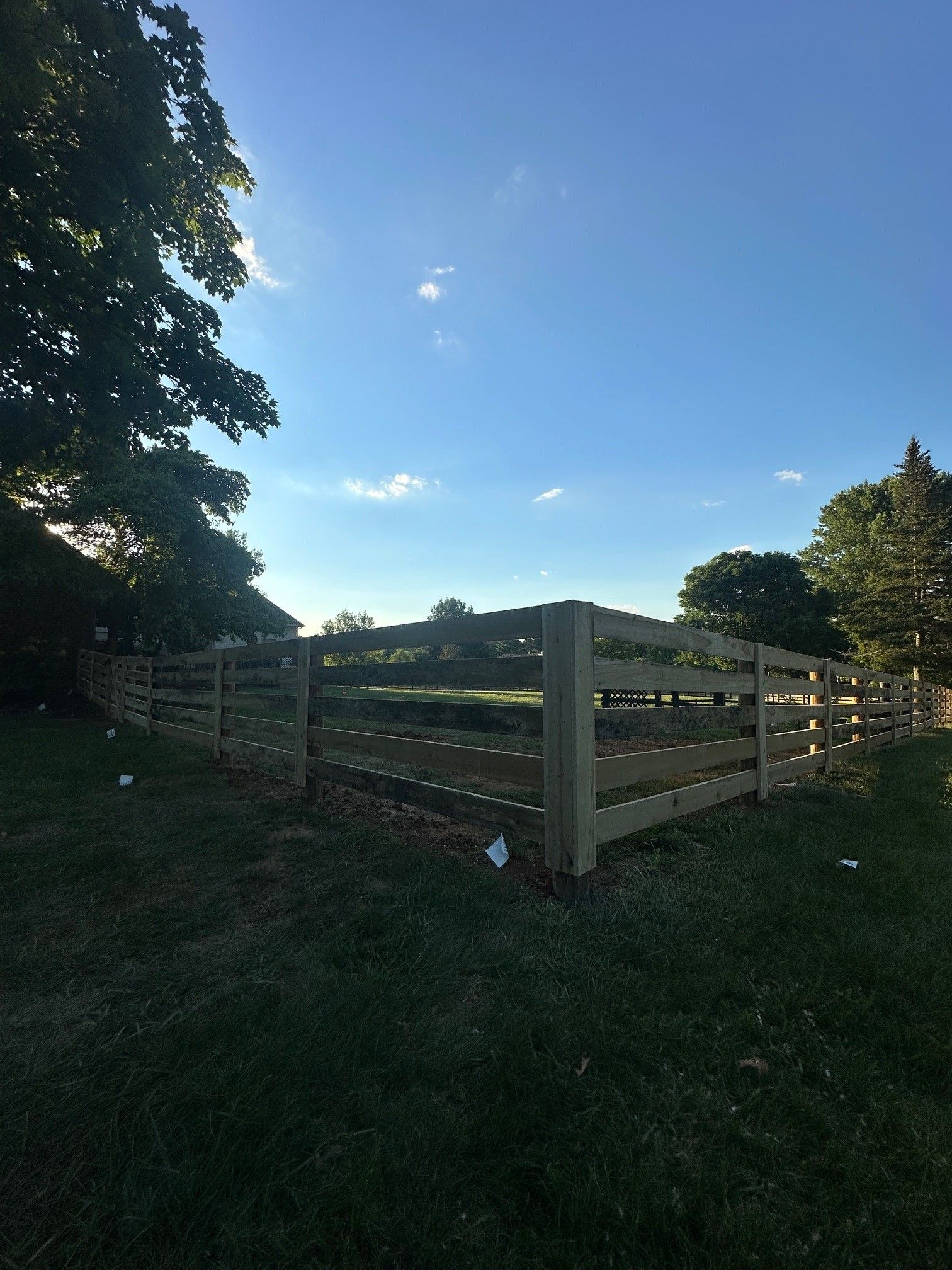 A wooden fence is in the middle of a grassy field — Lexington, KY — Chafin Fence LLC