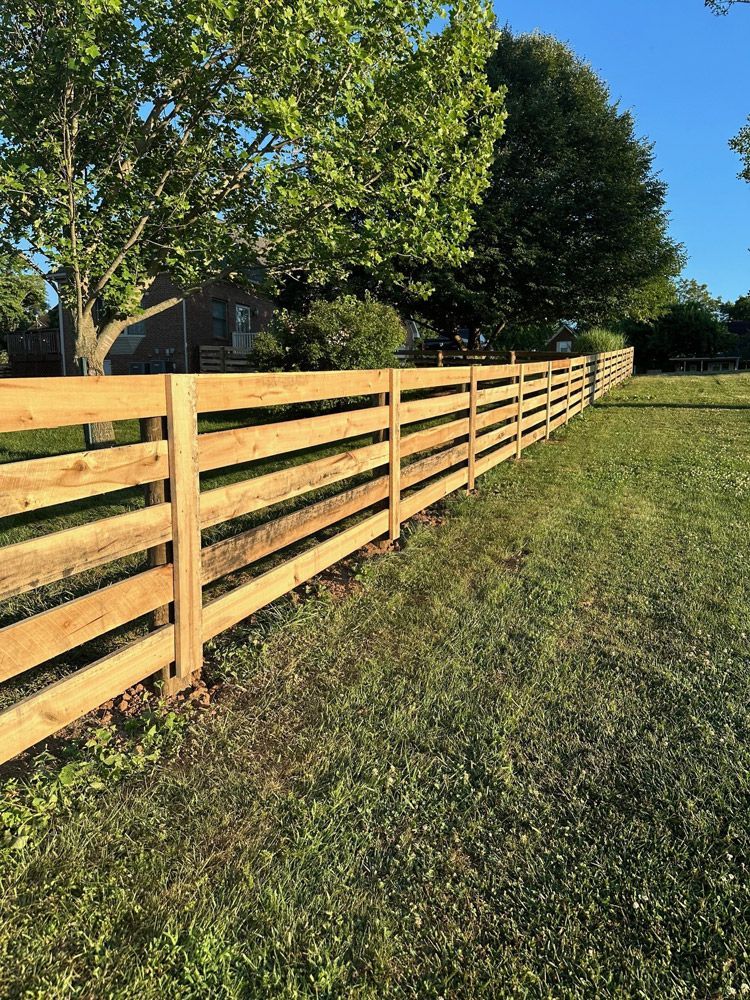 A wooden fence is sitting in the middle of a grassy field.