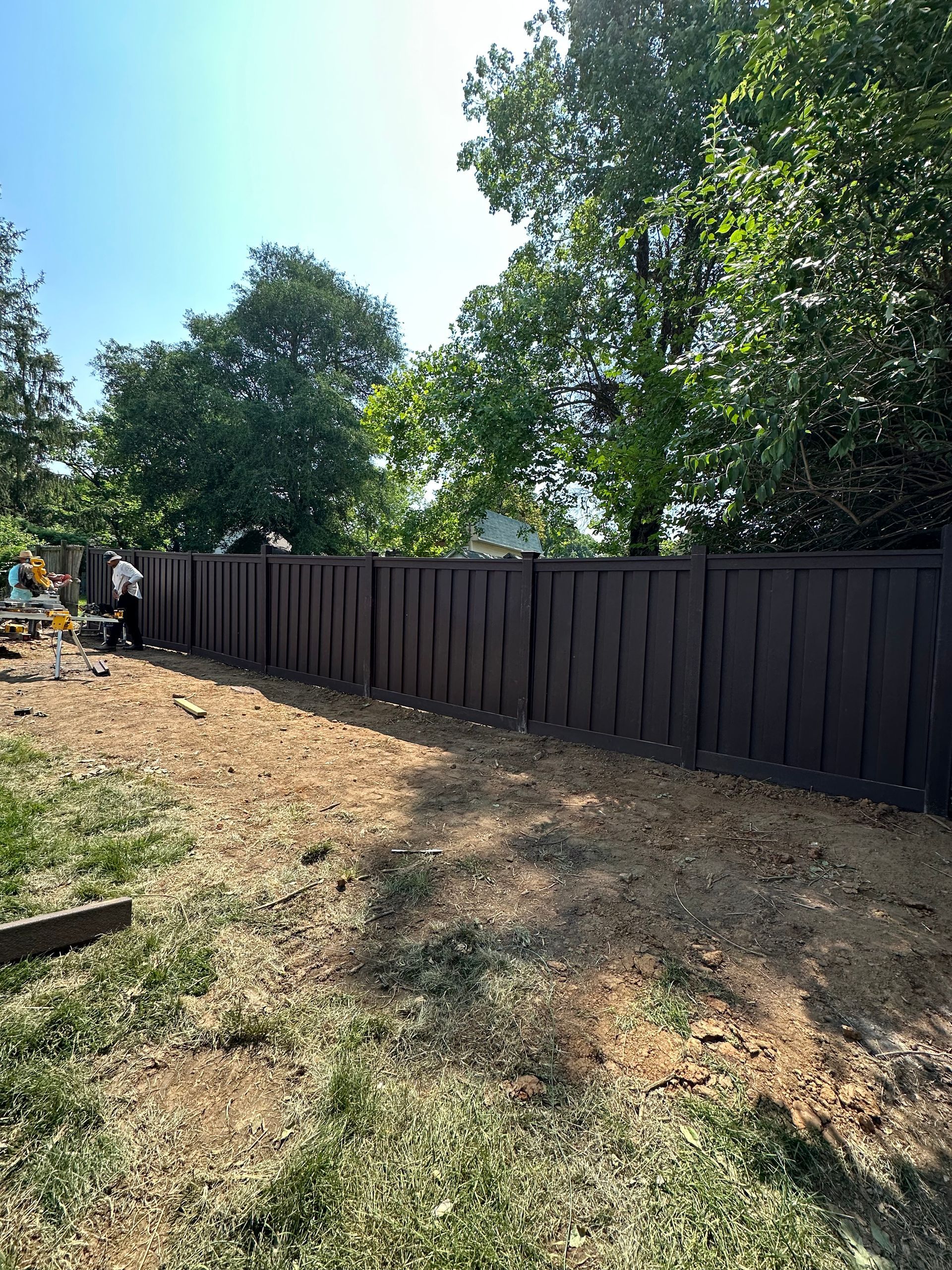 a wooden fence is being built in a backyard with trees in the background — Lexington, KY — Chafin Fence LLC