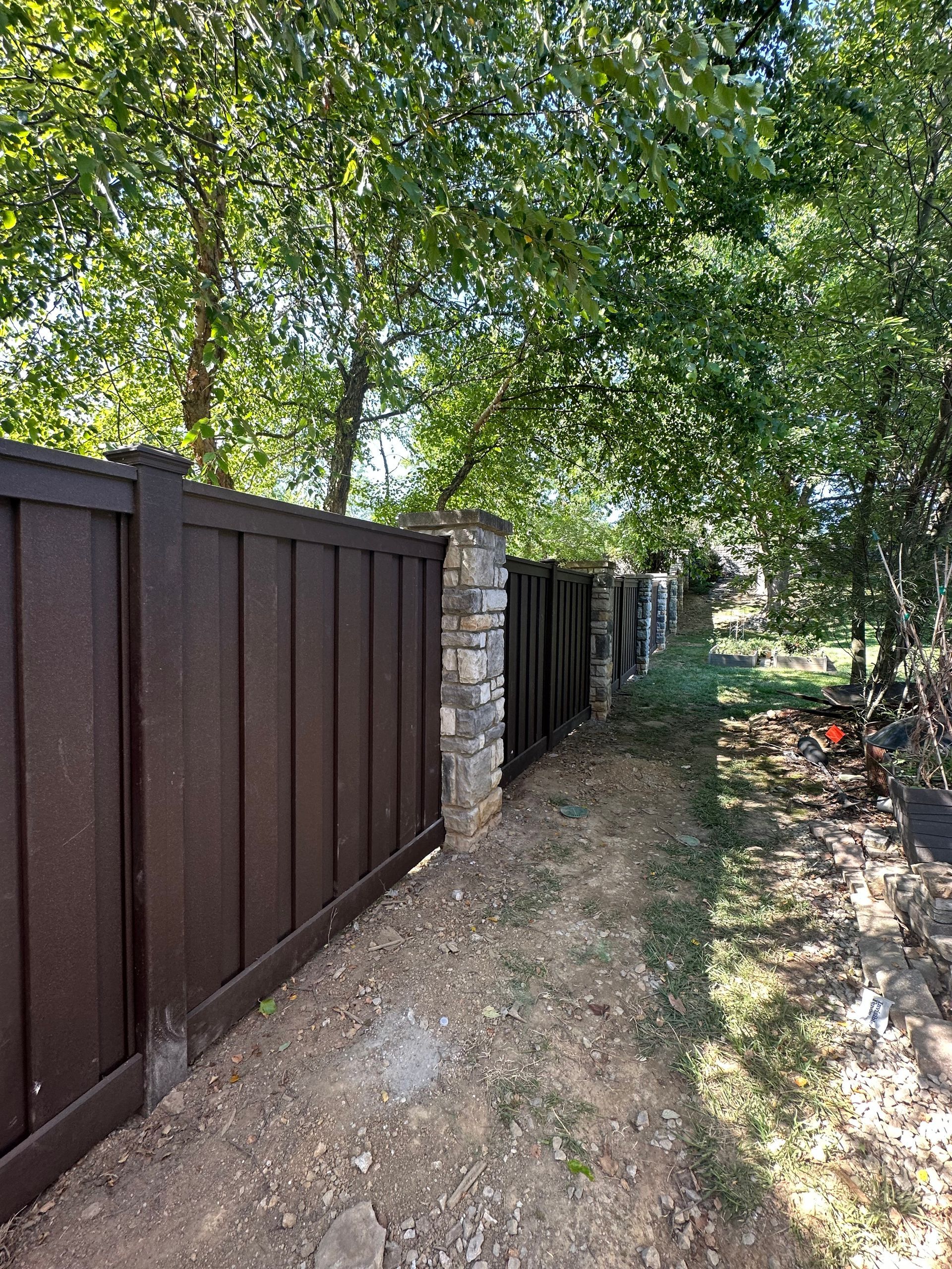 A wooden fence surrounds a dirt path in a backyard – Lexington, KY - Chafin Fence LLC