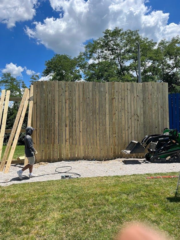 a man is standing in front of a wooden fence — Lexington, KY — Chafin Fence LLC
