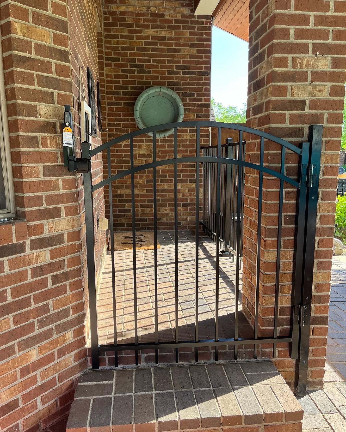 Black gate is sitting in front of a brick building – Lexington, KY - Chafin Fence LLC