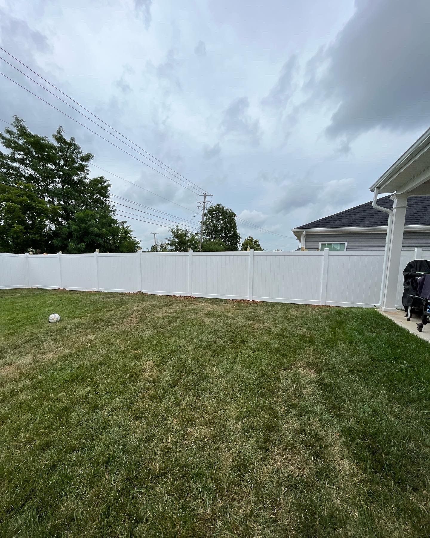 a backyard with a white fence and a house in the background — Lexington, KY — Chafin Fence LLC