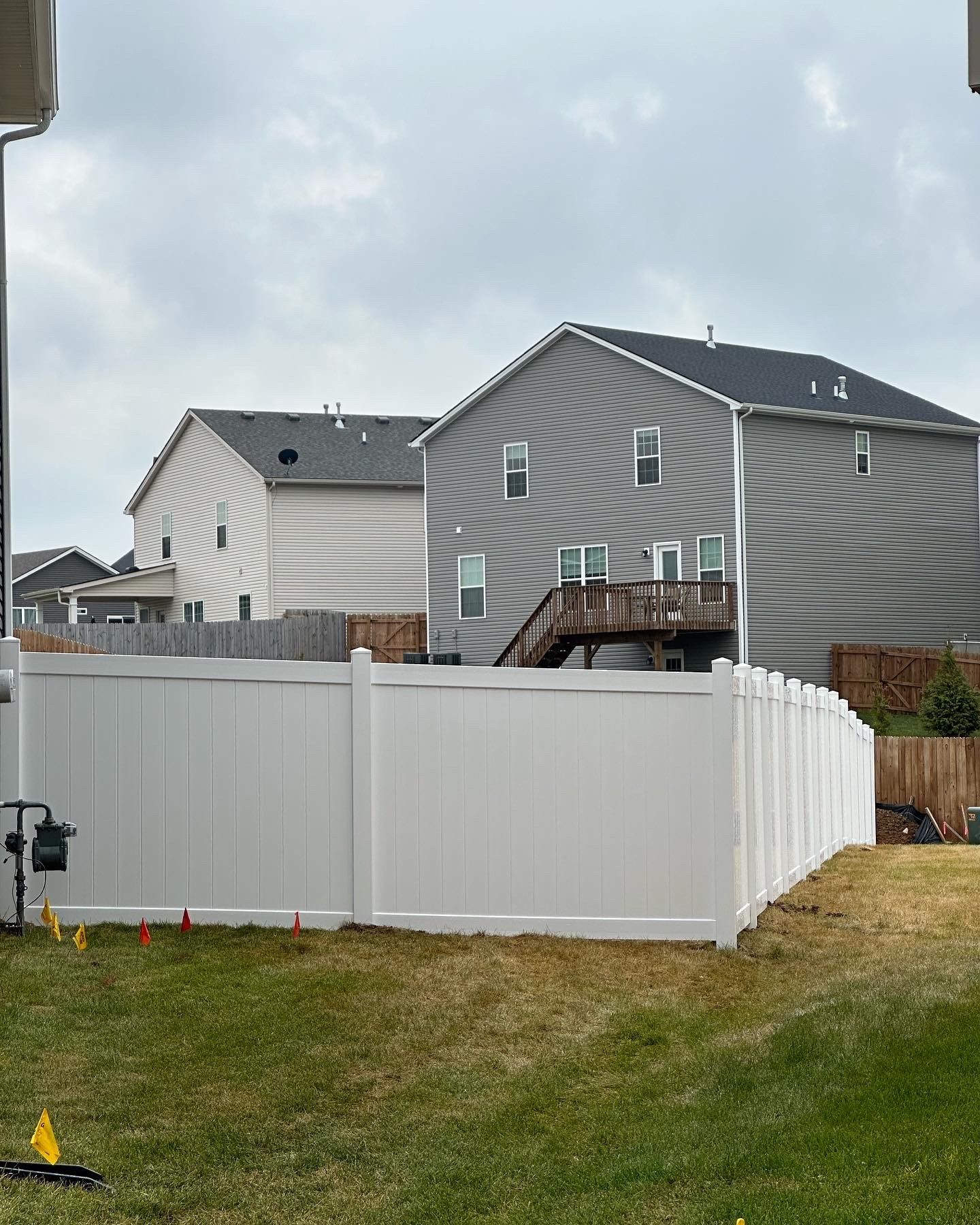 a white fence surrounds a yard with a house in the background — Lexington, KY — Chafin Fence LLC
