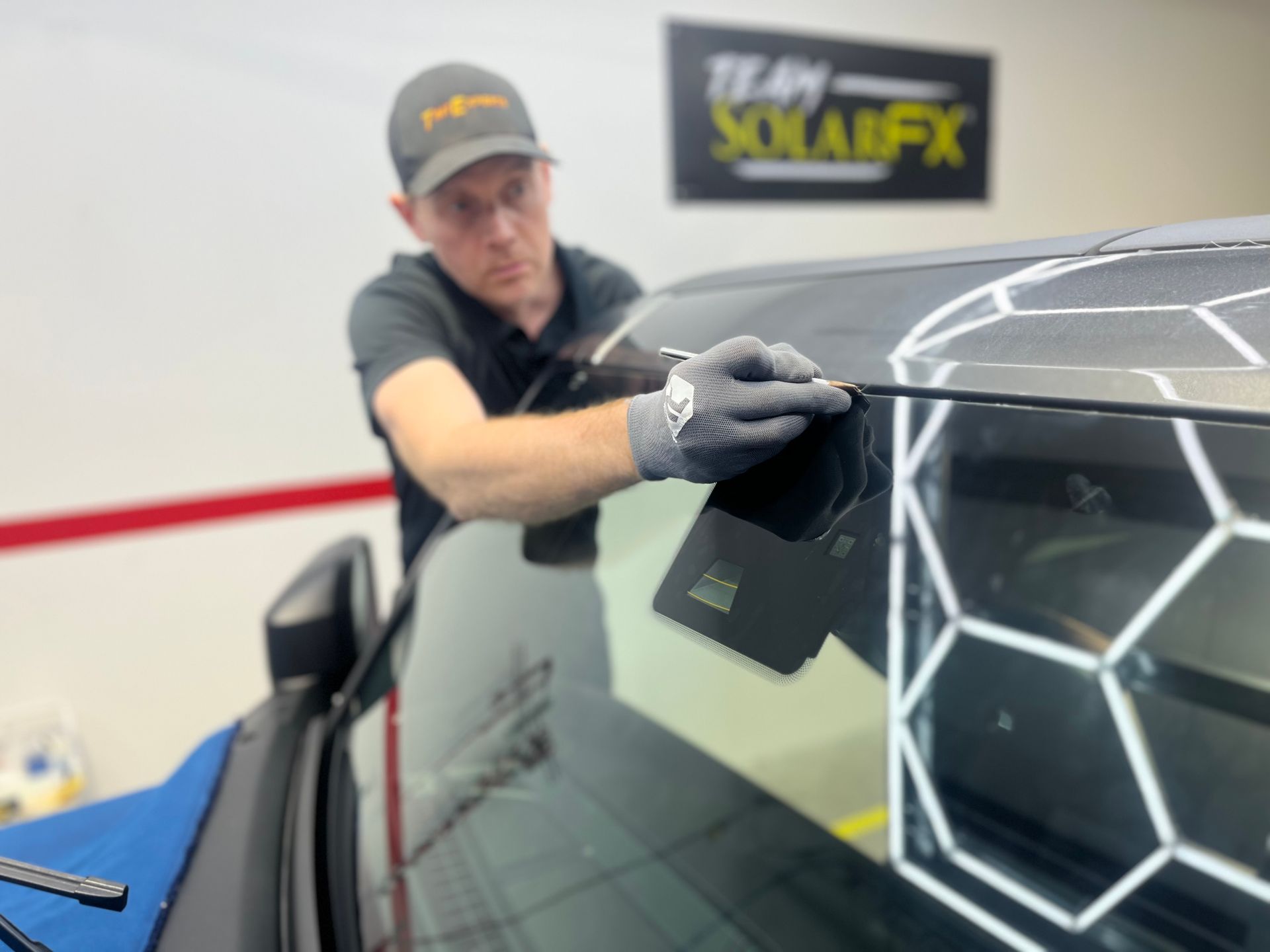 A man is working on the windshield of a car