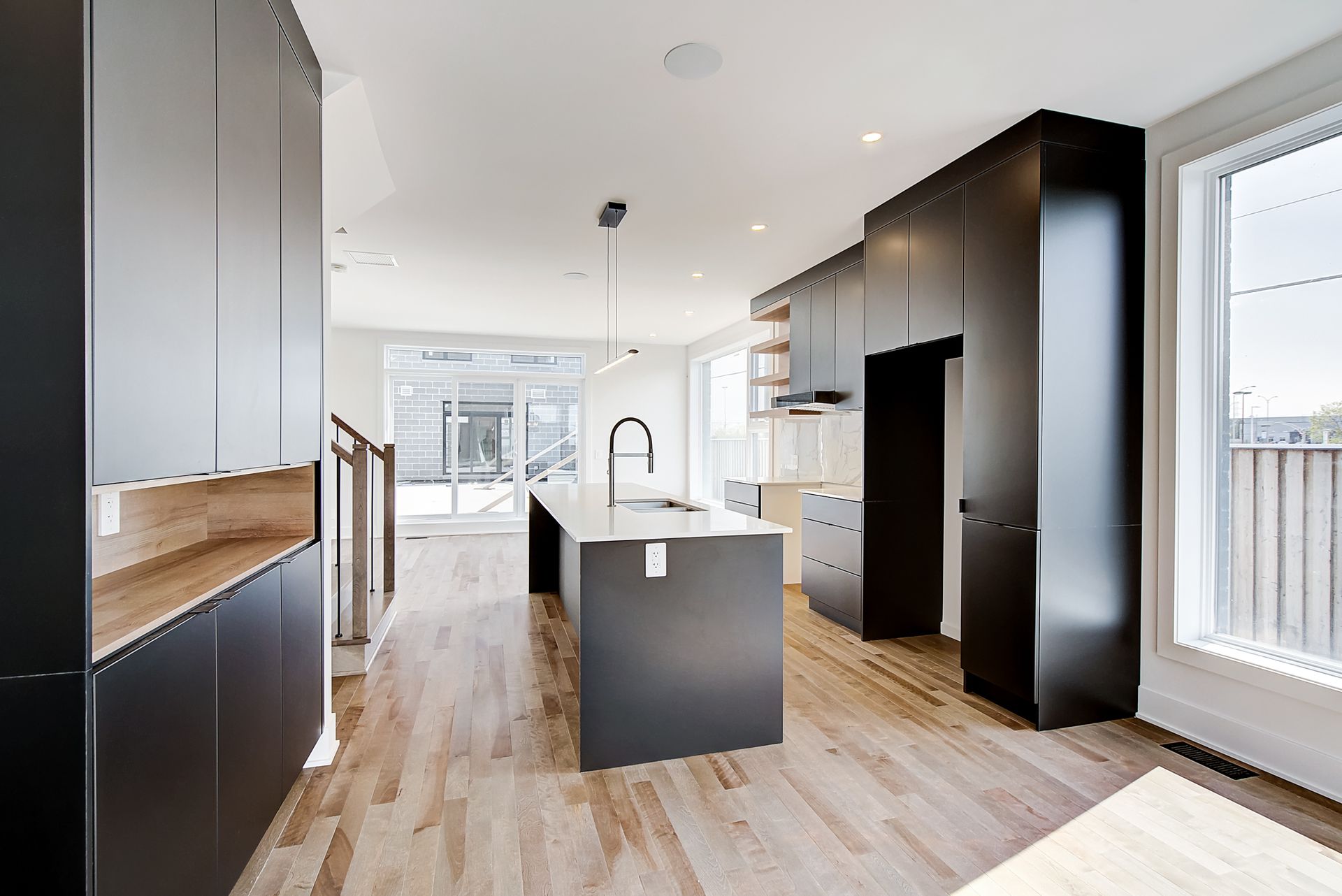 Une cuisine avec armoires noires et un grand îlot au milieu