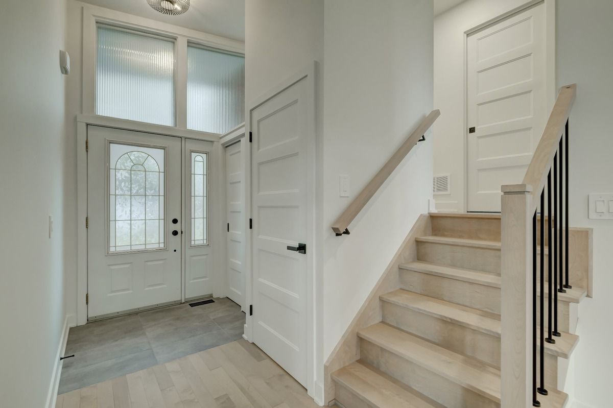 Un couloir avec des escaliers menant au deuxième étage d'une maison.