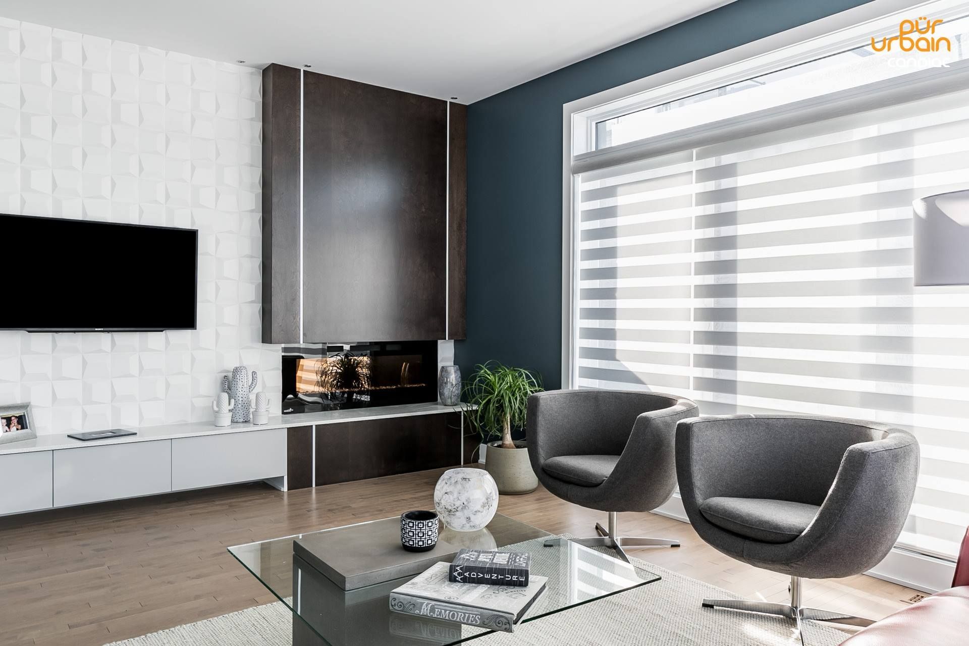 Un séjour avec deux chaises , une table basse , une télévision écran plat et une cheminée.